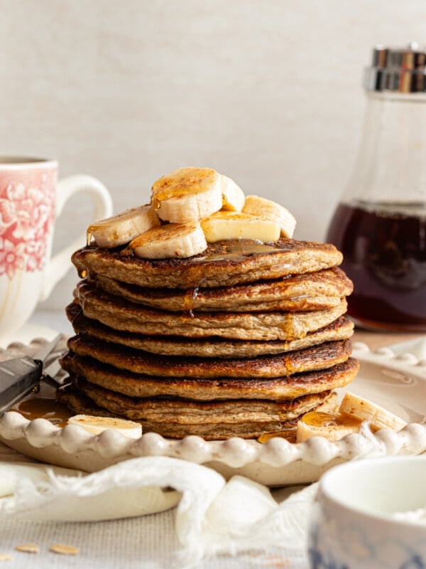 A stack of banana cottage cheese pancakes topped with sliced bananas.