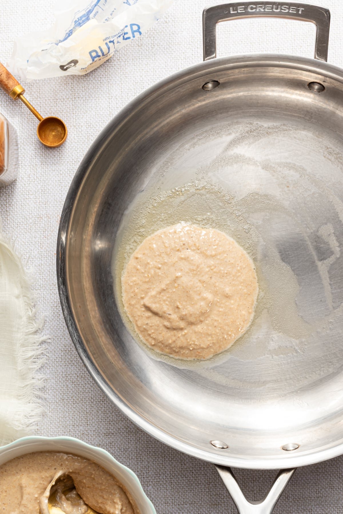 Banana cottage cheese pancake batter being added to a hot pan.