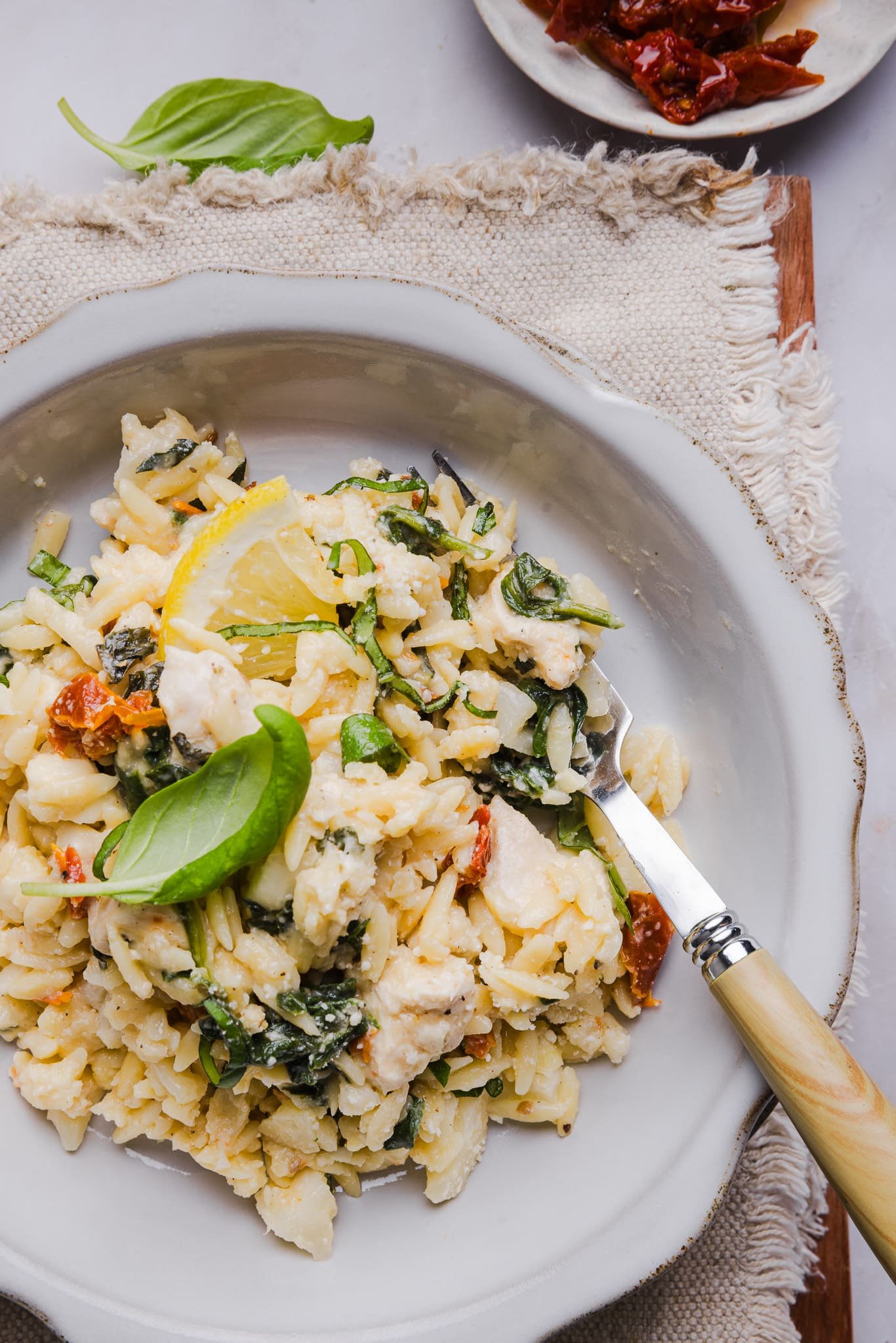 Chicken and orzo bake on a plate garnished with basil.