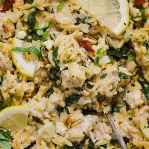 A close up shot of chicken orzo bake garnished with lemons.