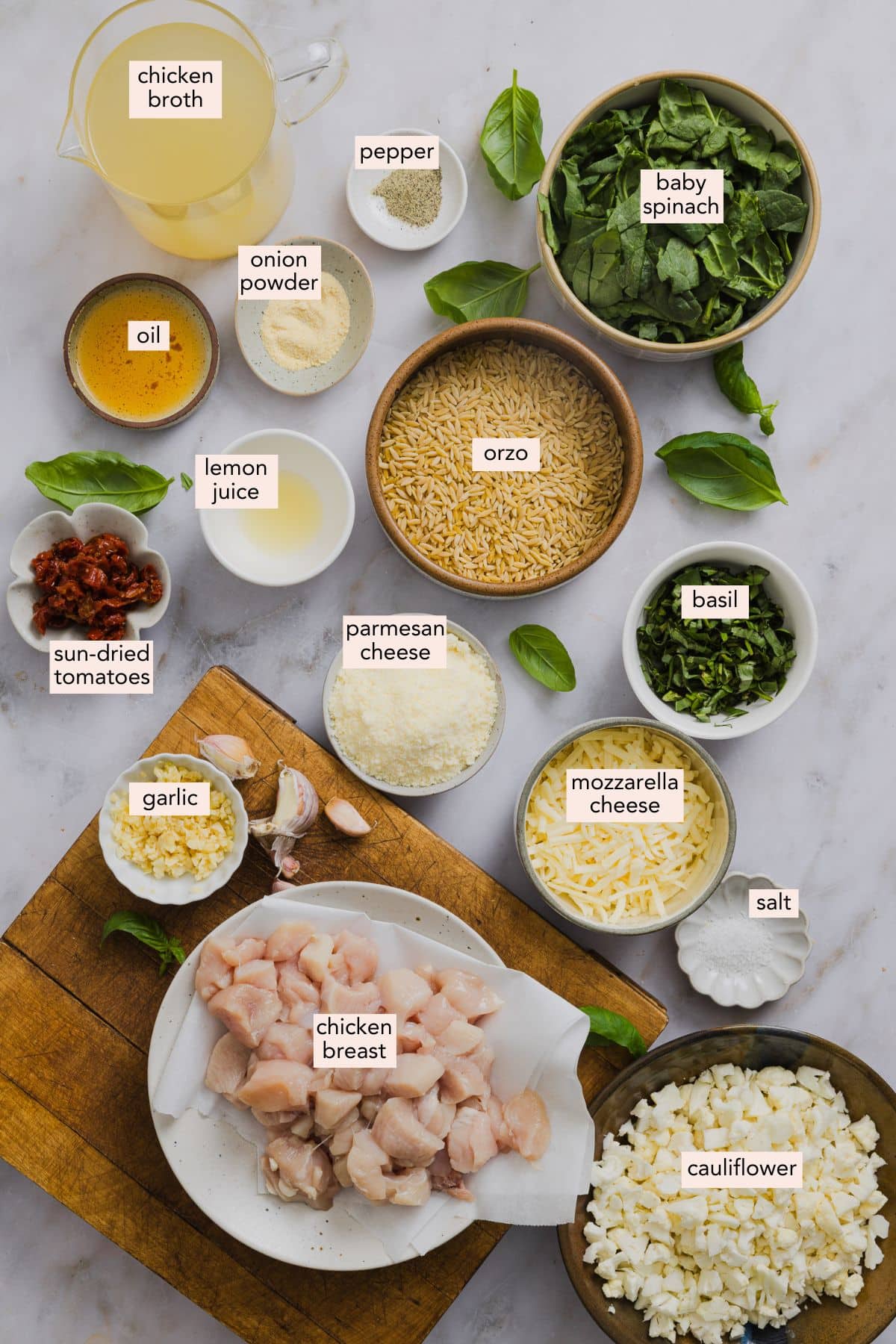 Ingredients for a chicken orzo bake on a countertop with labels.