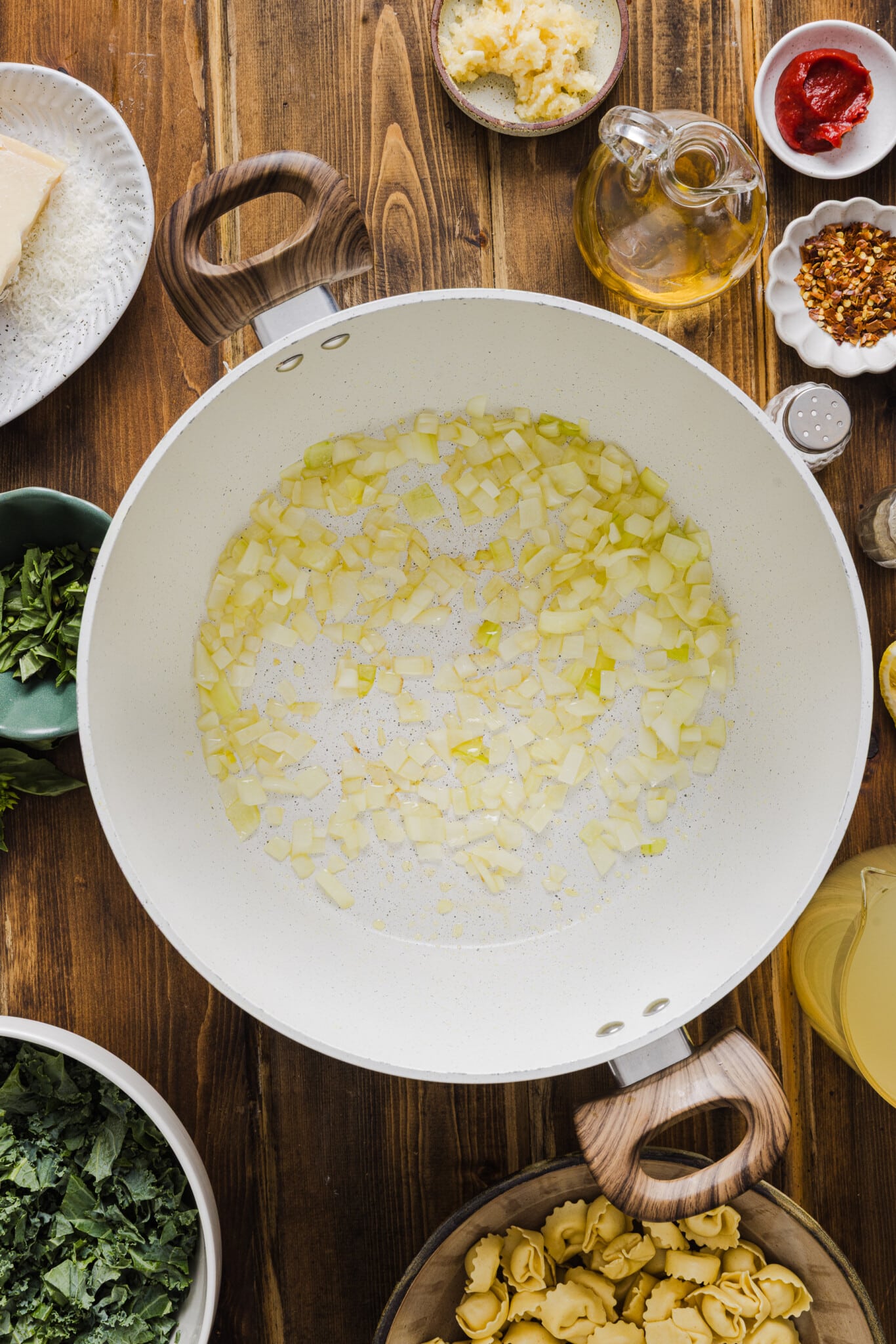 A large soup pot with olive oil and sautéed diced onion.