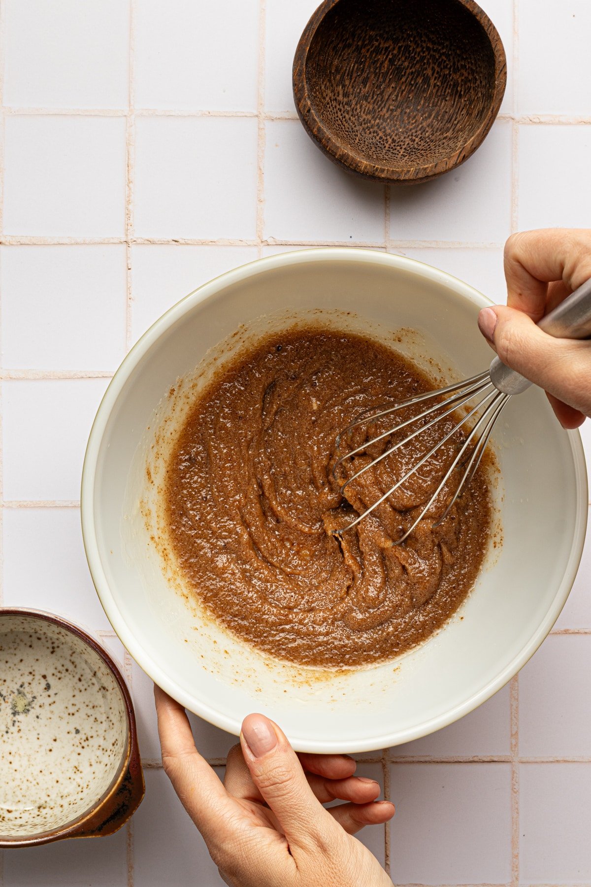 Melted butter, brown and white sugar being whisked in a bowl.