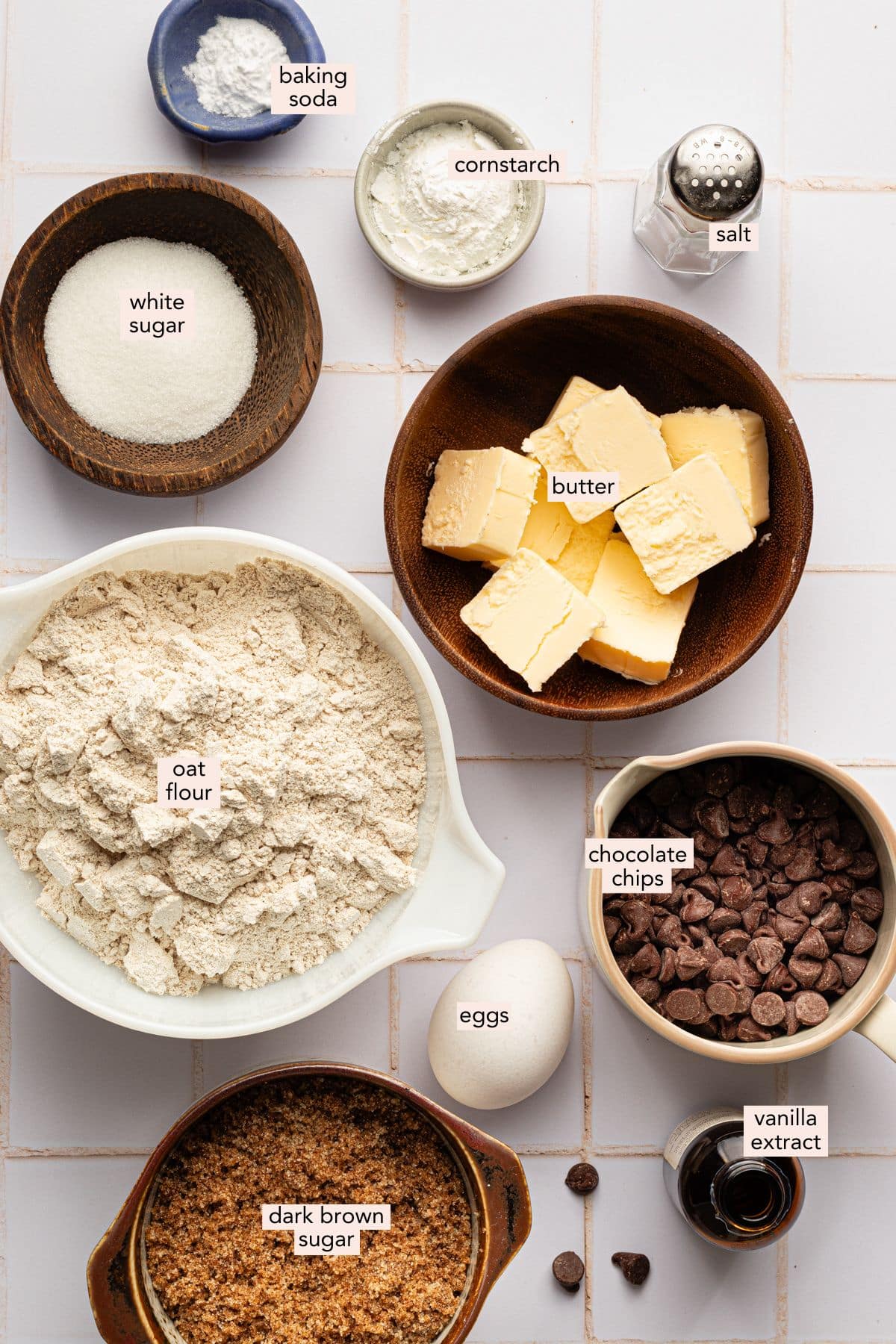 Oat flour chocolate chip cookie ingredients in individual bowls with labels.