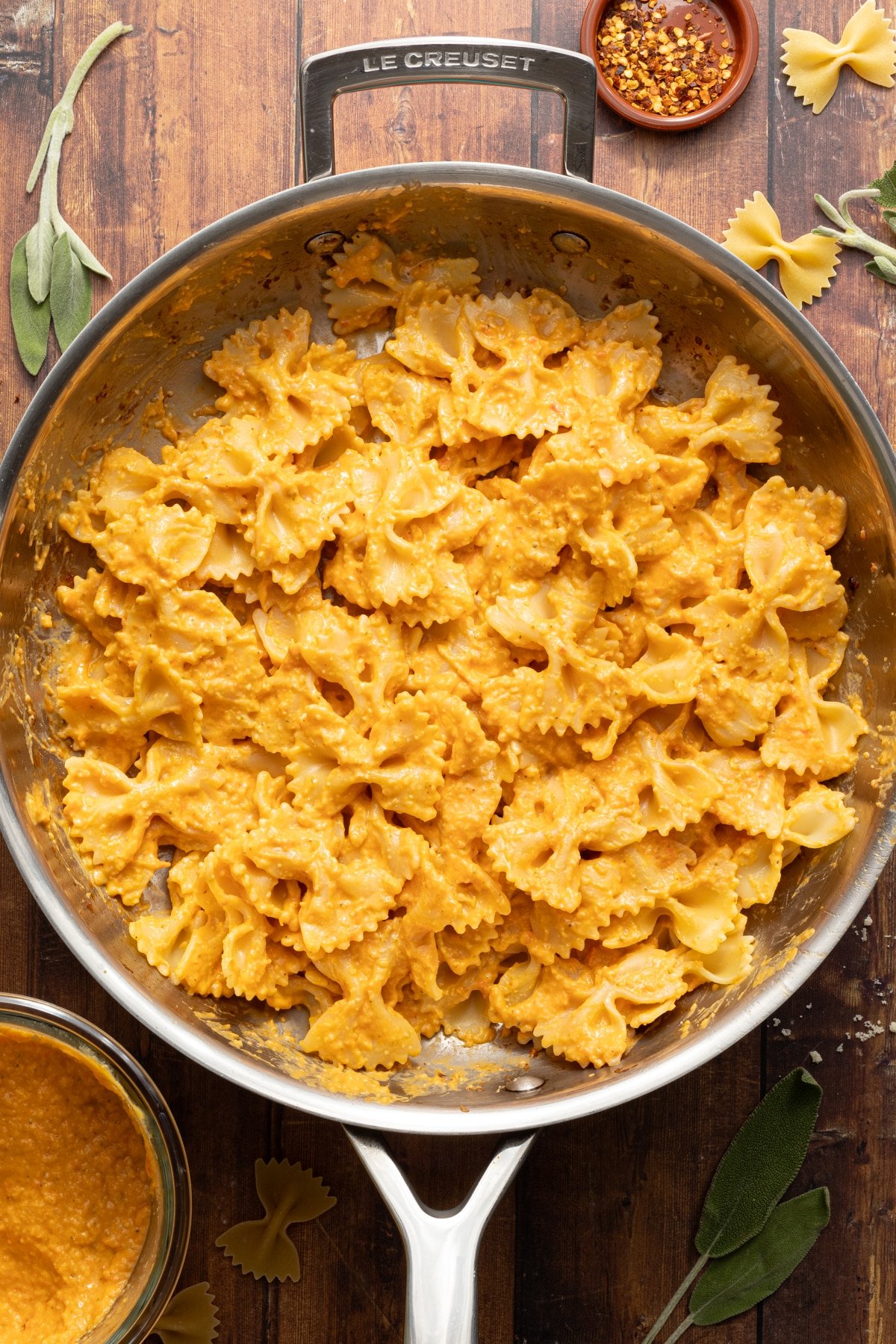 Pasta tossed in pumpkin sauce in a skillet.