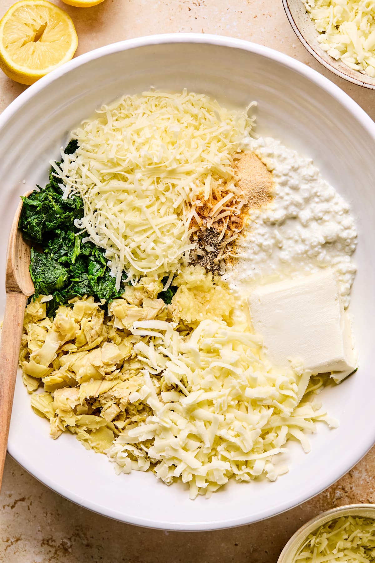 Ingredients for cottage cheese spinach artichoke dip in a bowl ready to be mixed for spinach artichoke dip.