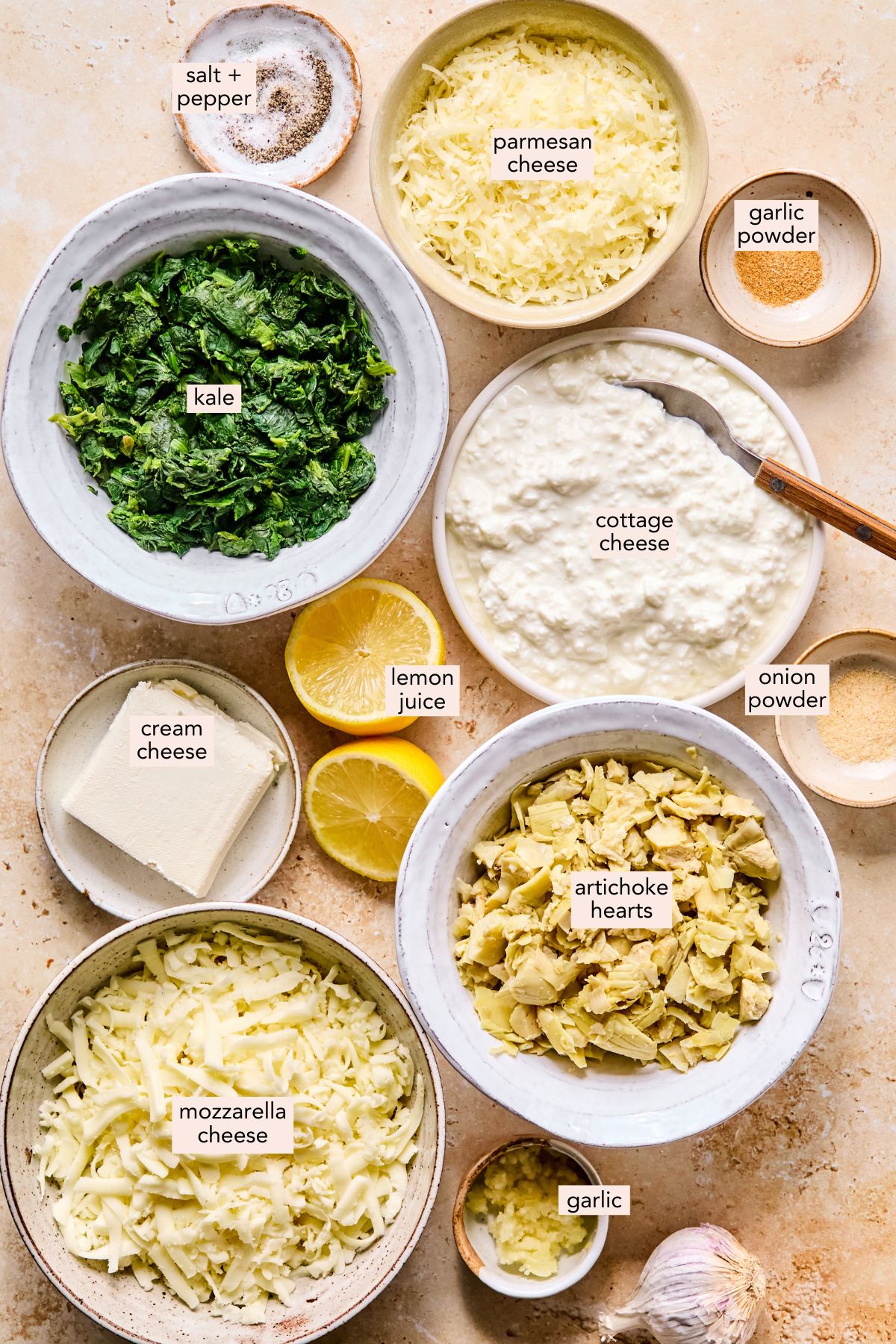 Ingredients for cottage cheese spinach artichoke dip on a countertop with labels.