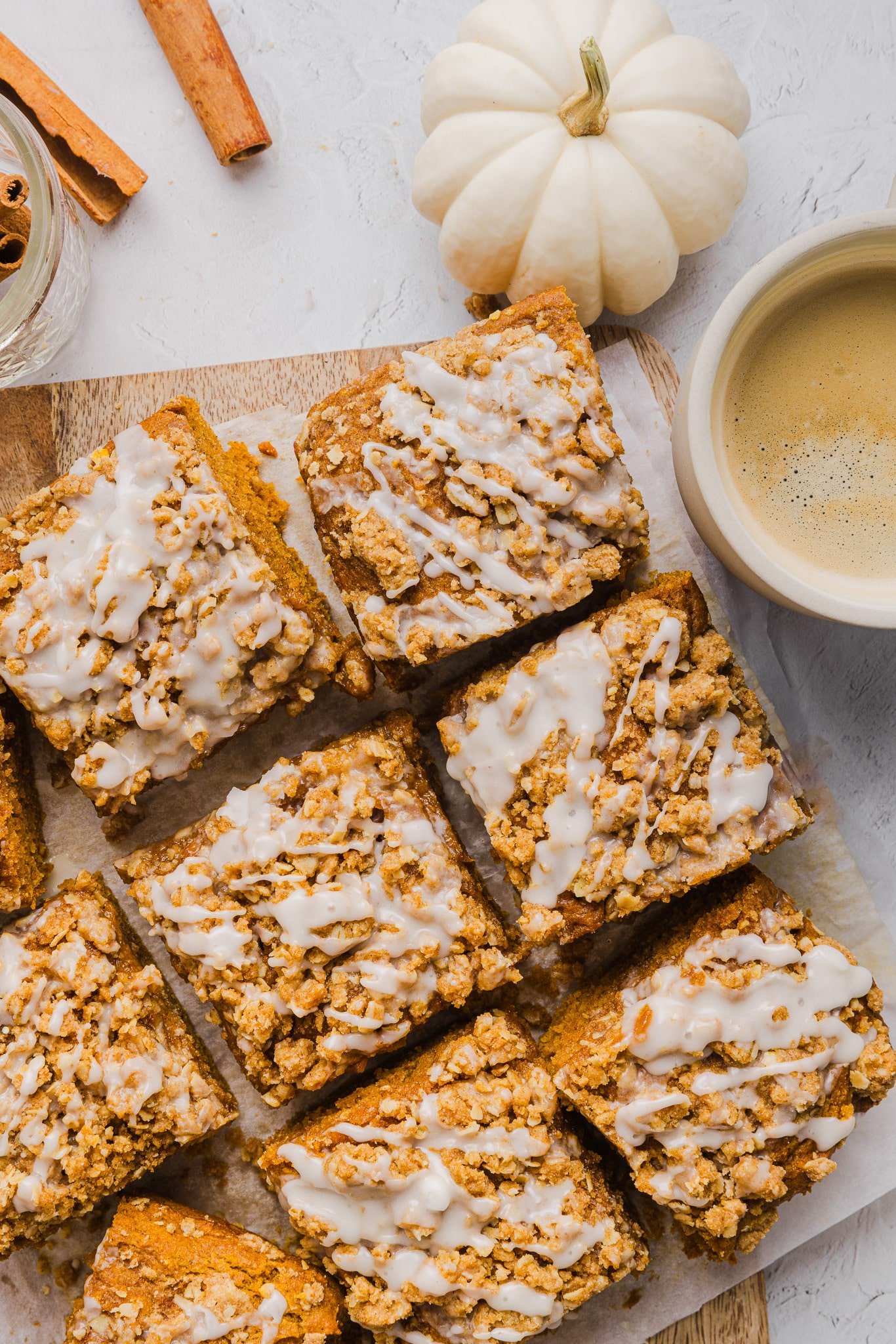 Slices of healthy pumpkin coffee cake on a wooden board with a cup of coffee.