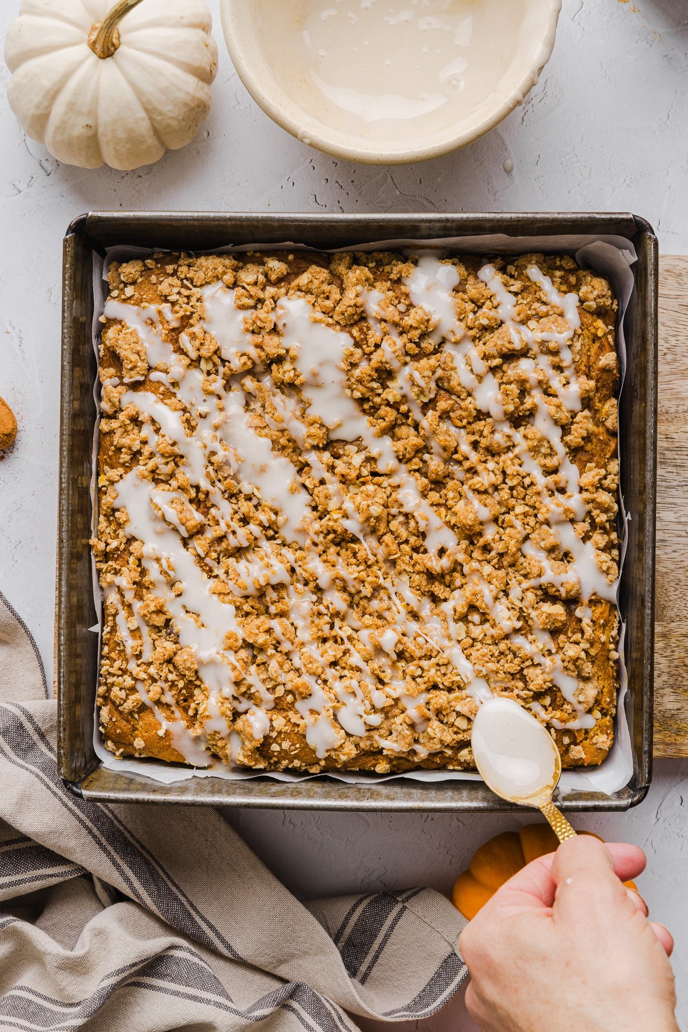 A baked healthy pumpkin coffee cake drizzled with glaze.