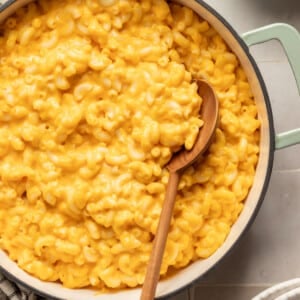 Hidden veggie Mac and cheese in a pot with a wooden spoon.