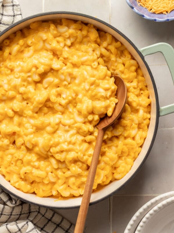 Hidden veggie Mac and cheese in a pot with a wooden spoon.