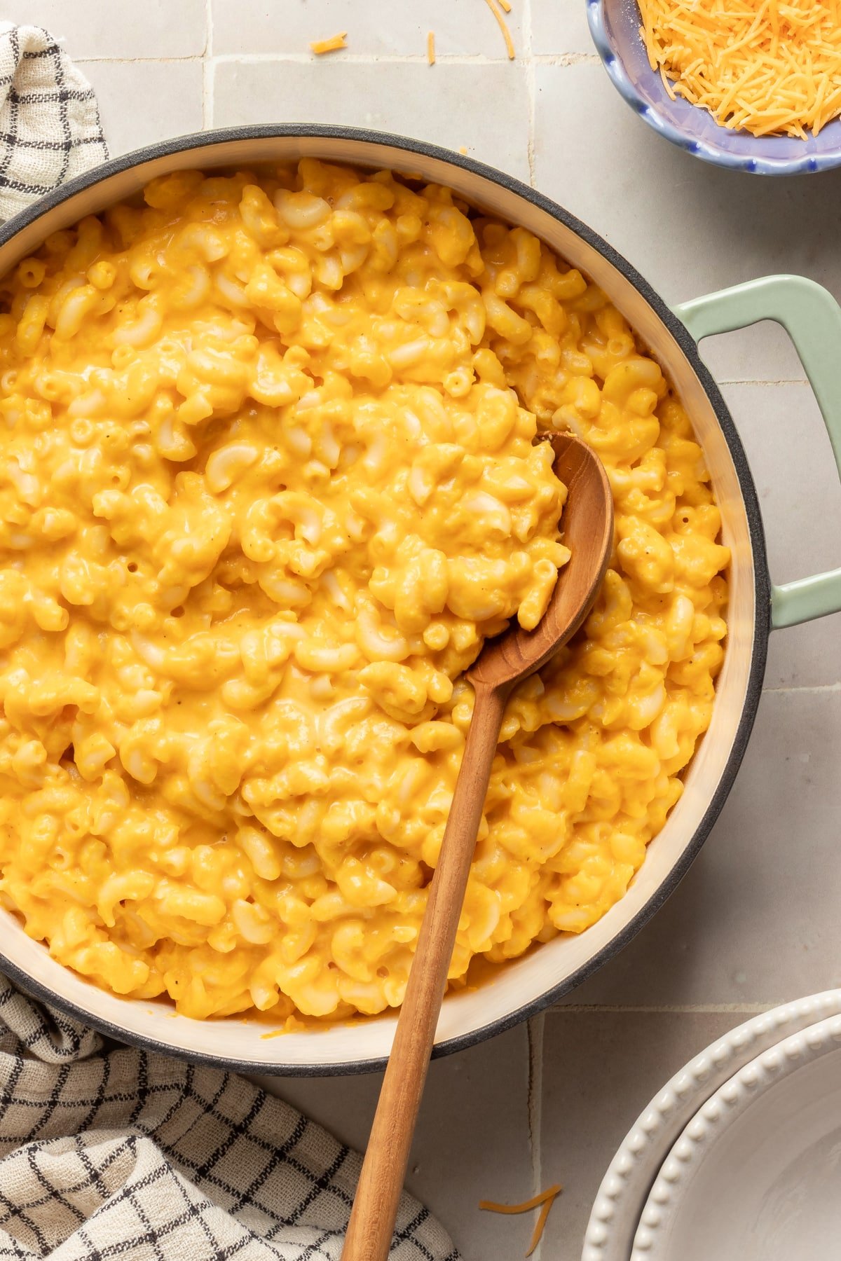 Hidden veggie Mac and cheese in a pot with a wooden spoon.