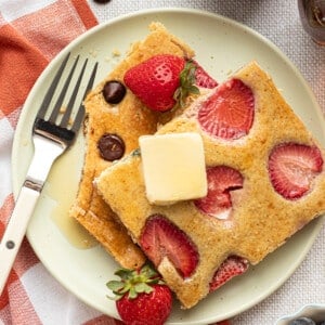 Sliced sheet pan protein pancakes on a plate with butter.