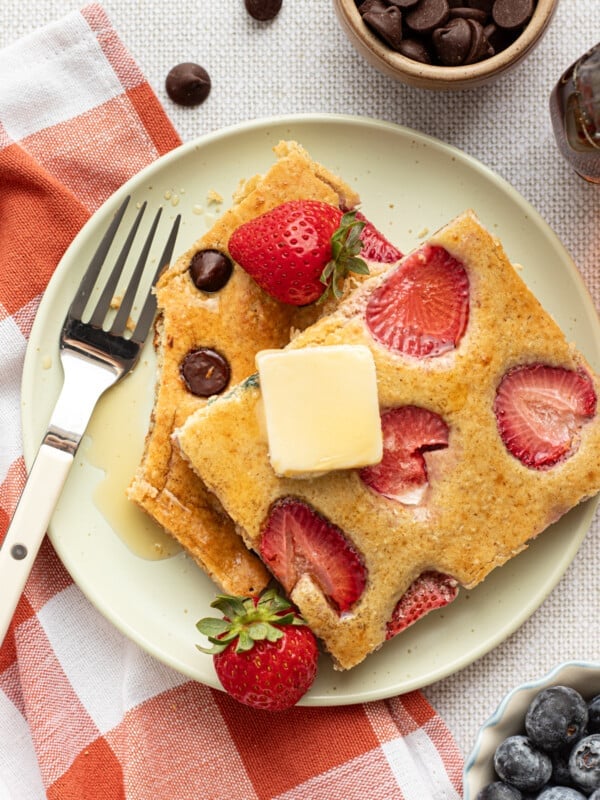 Sliced sheet pan protein pancakes on a plate with butter.