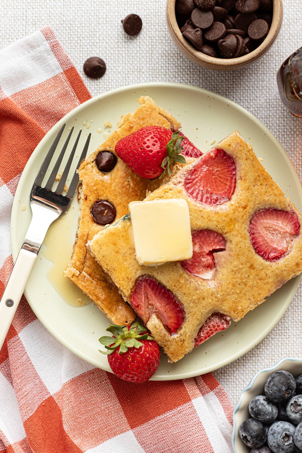 Sliced sheet pan protein pancakes on a plate with butter.