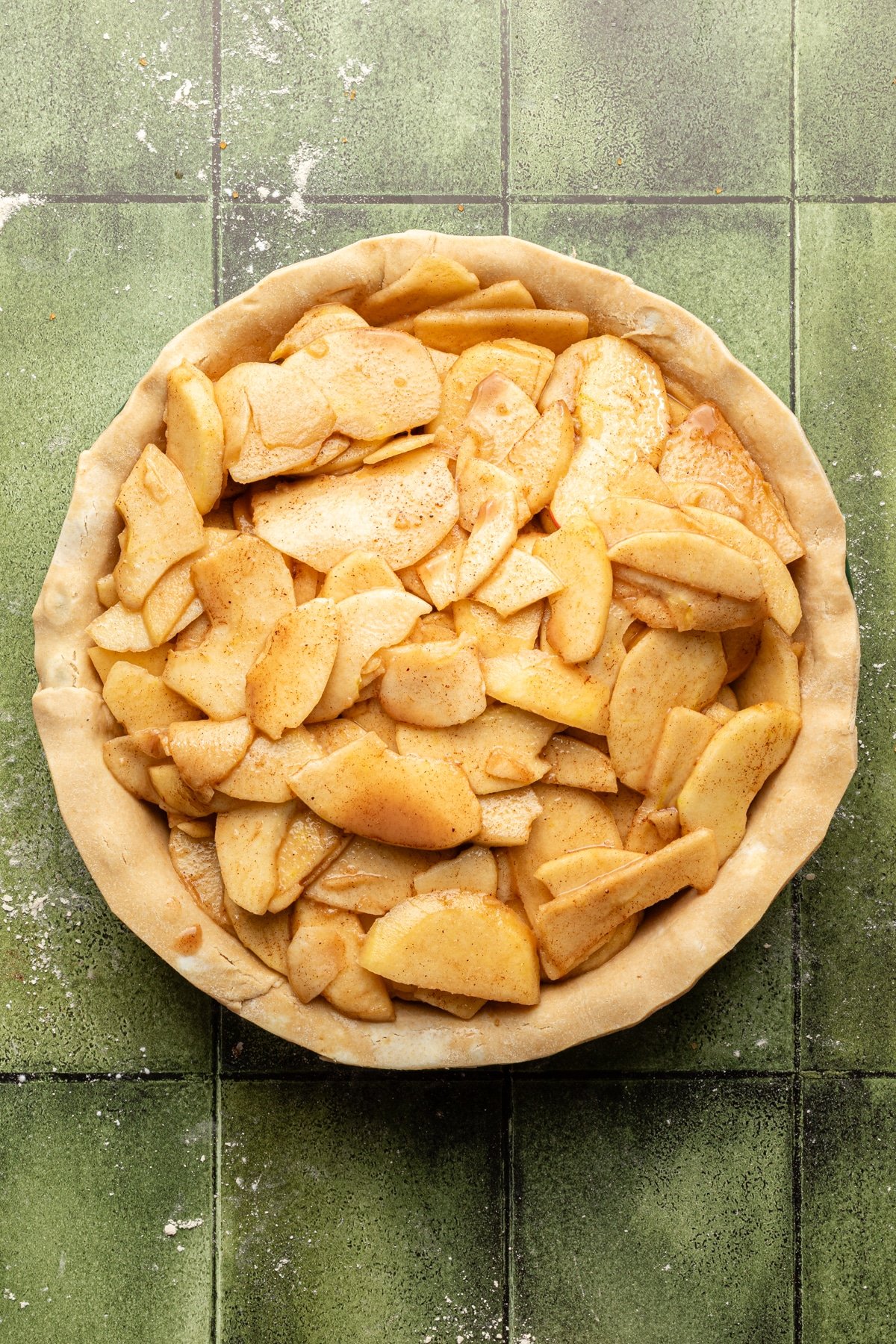Apple filling being added to apple pie.