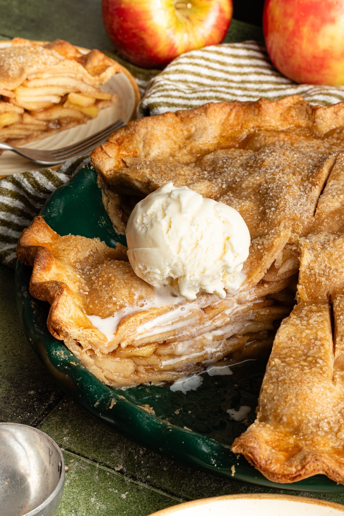 Healthy apple pie sliced in a dish and topped with vanilla ice cream.