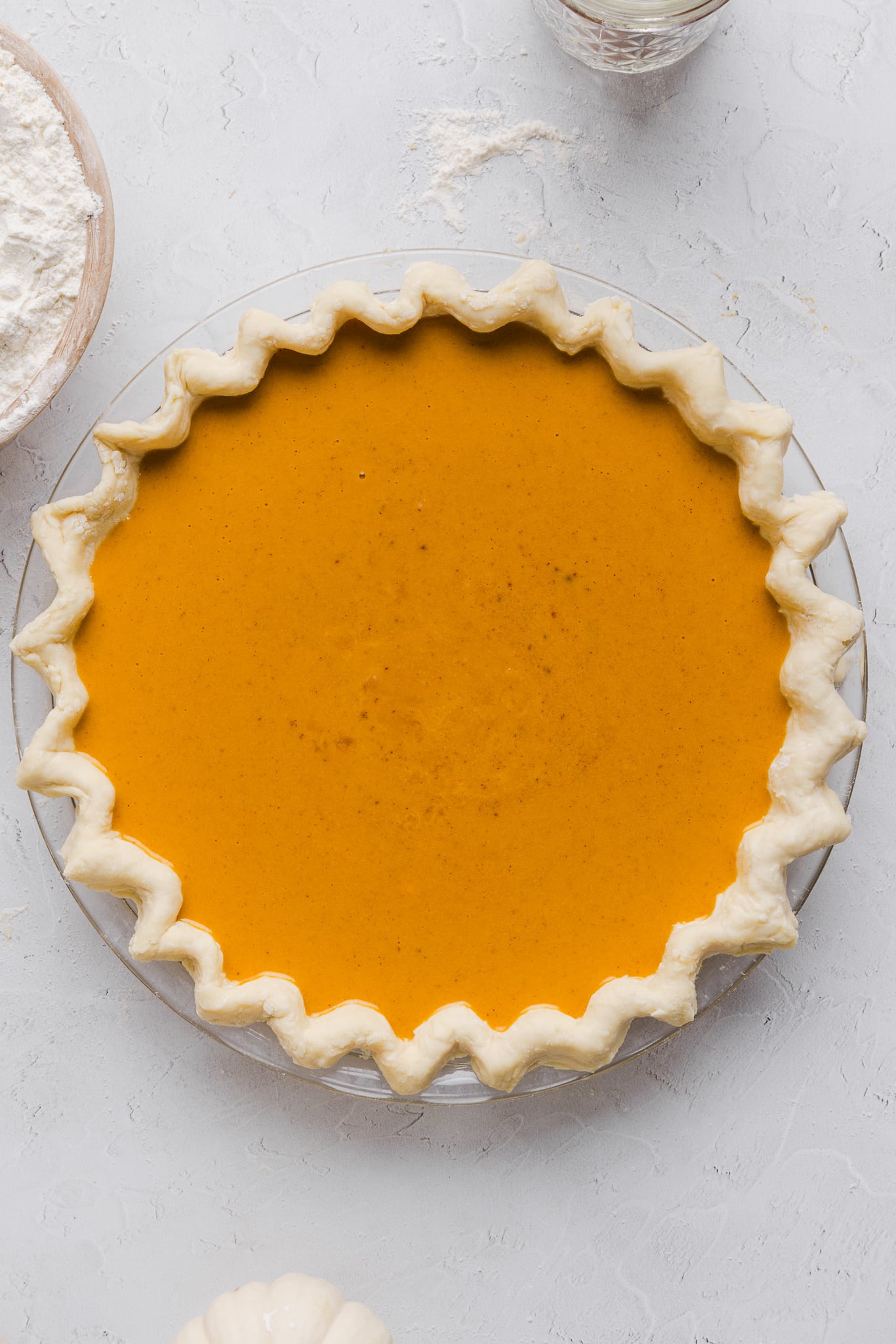 Healthy pumpkin pie filling poured into a crust in a pie pan.