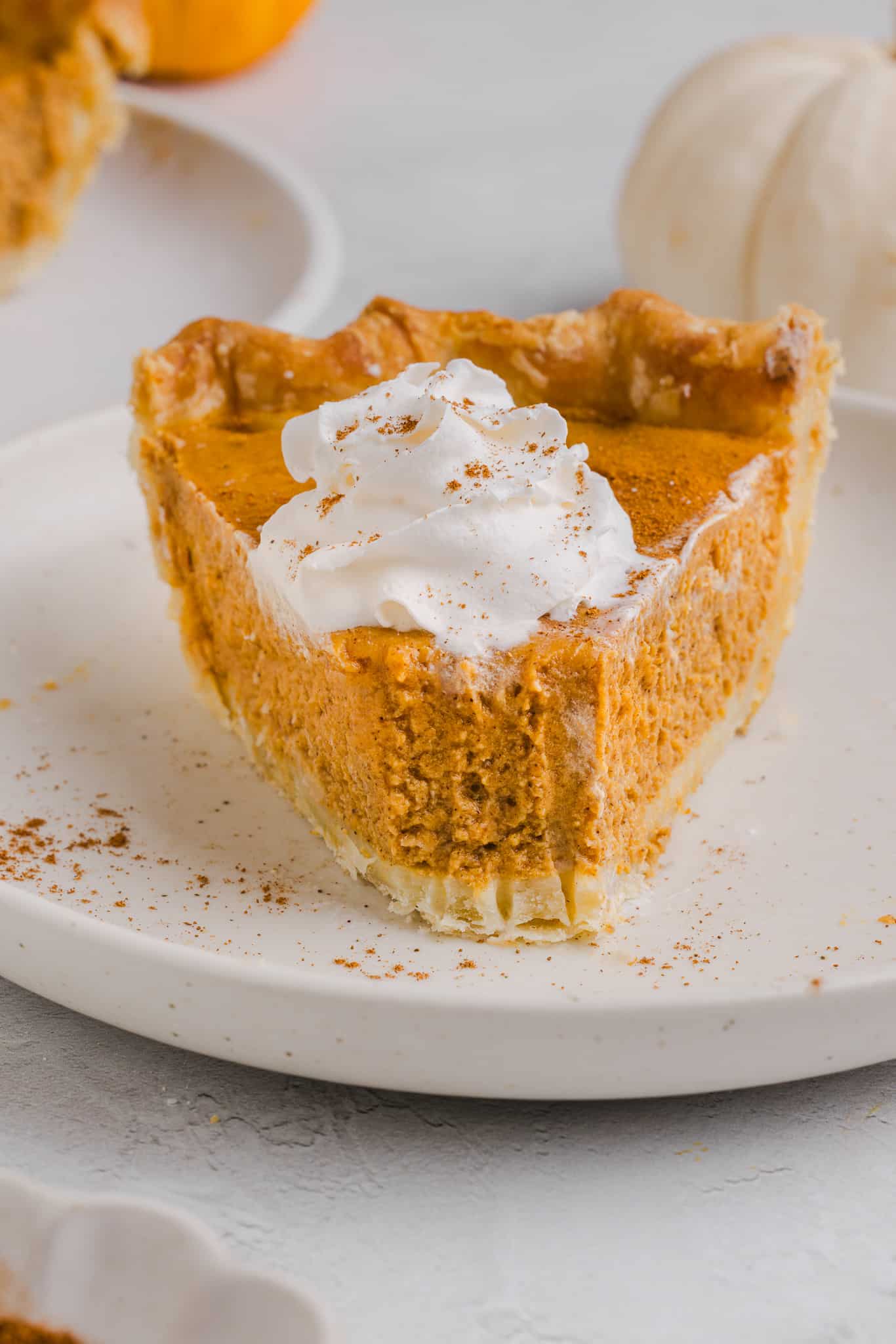 A slice of healthy pumpkin pie with whipped cream.