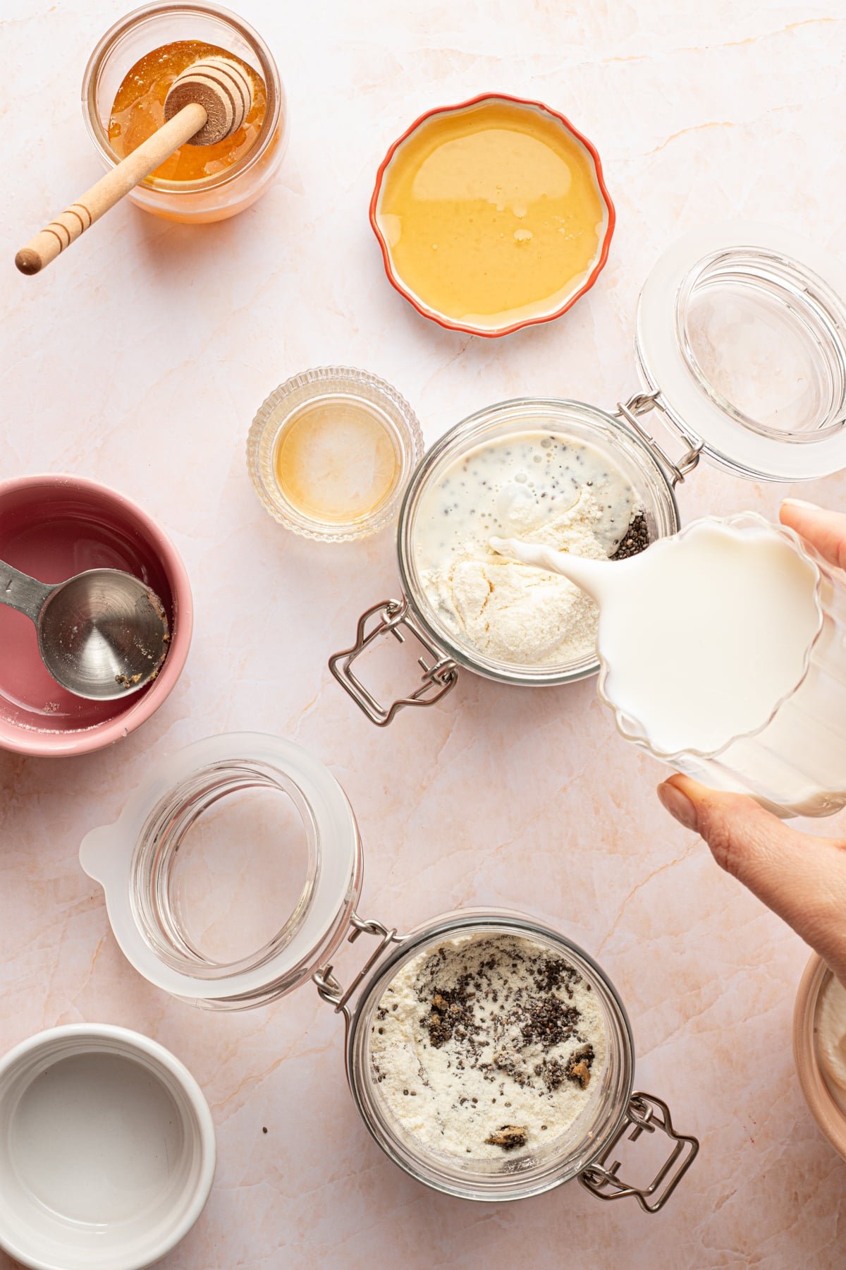 Protein chia pudding ingredients being mixed in jars.