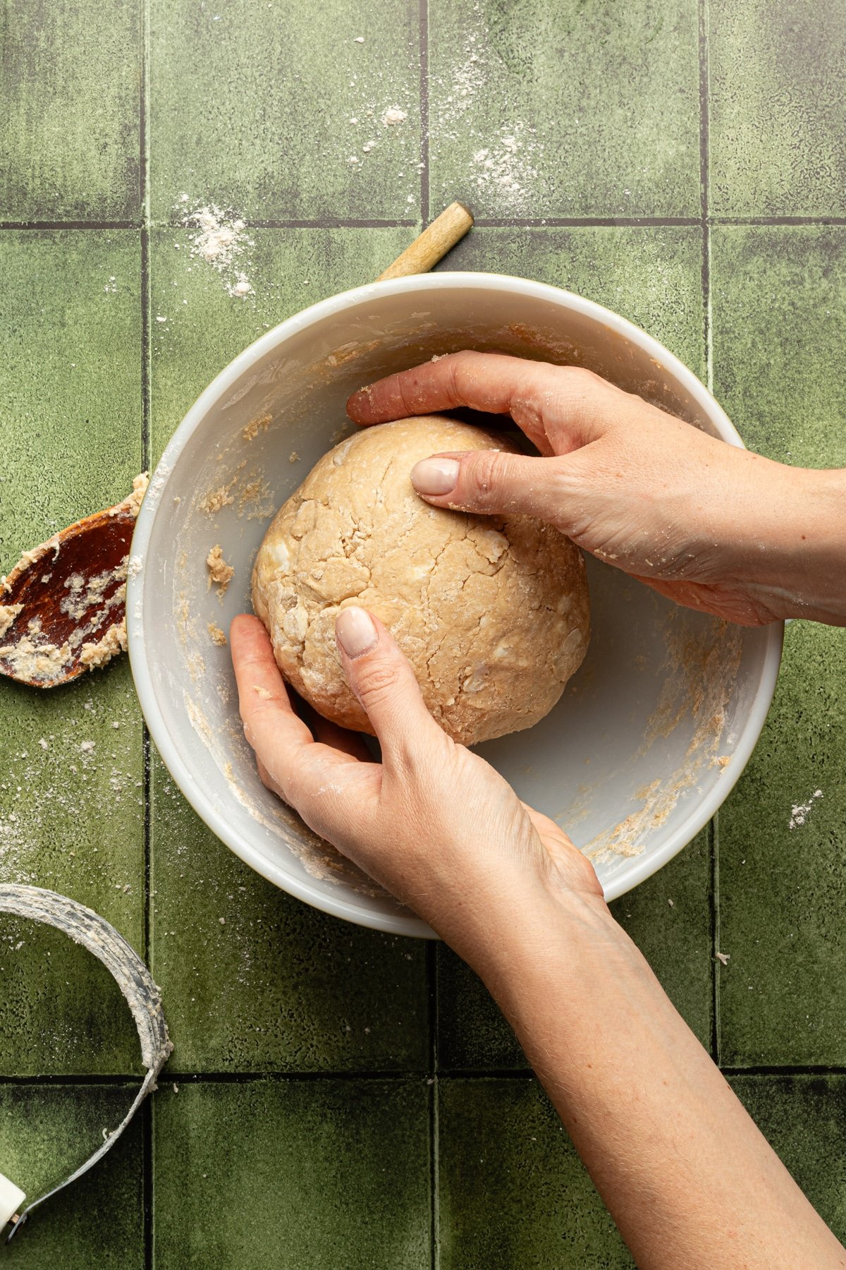 Whole wheat pie crust dough being formed into a ball.