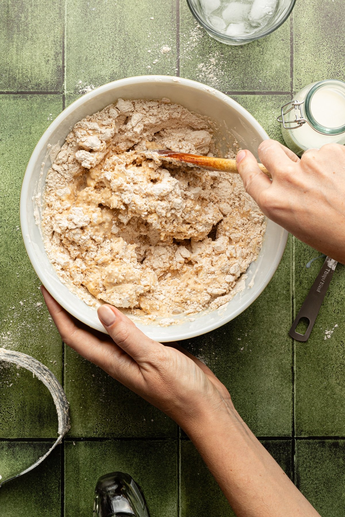 Whole wheat pie crust dough being mixed up with a wooden spoon.