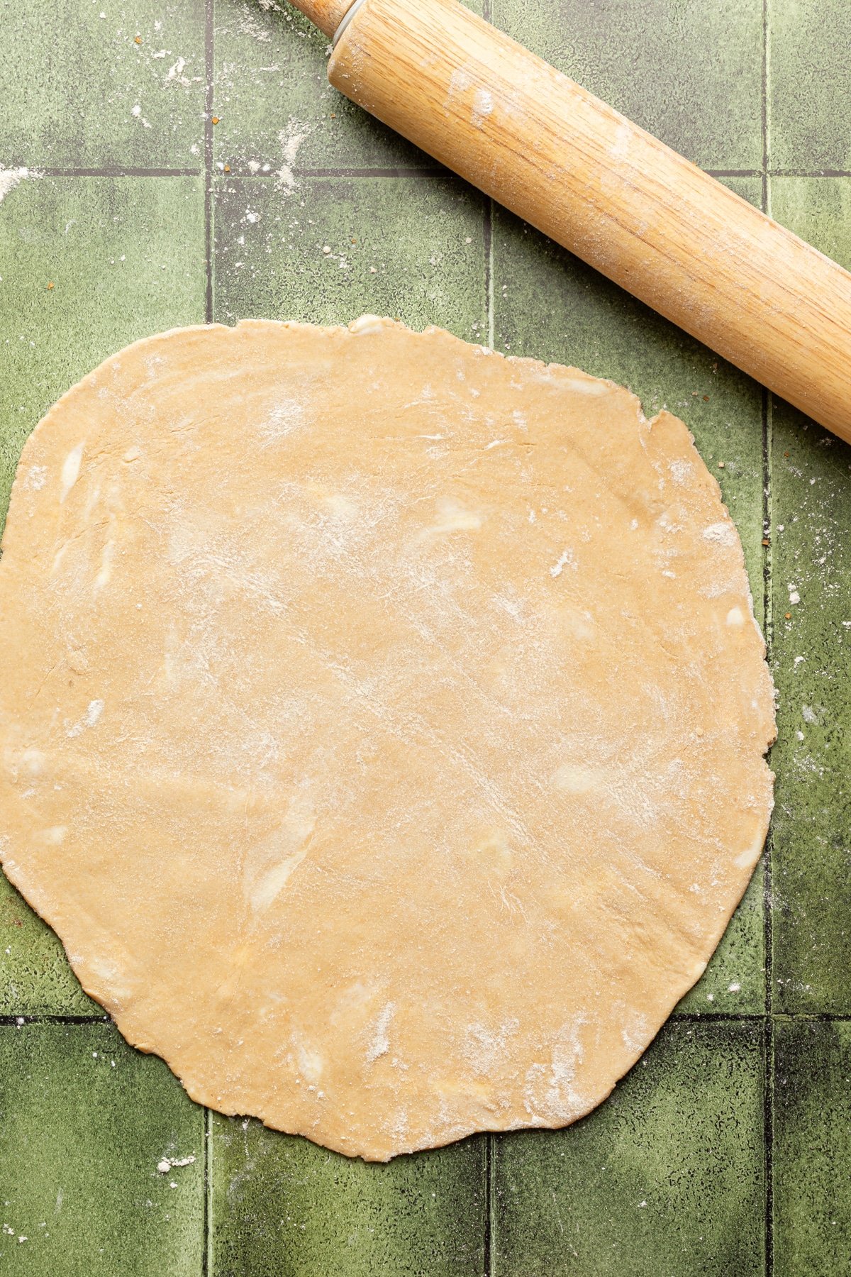 Whole wheat pie crust rolled out on a floured surface.