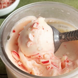 Ninja Creami peppermint ice cream being scooped out of the clear pint container.
