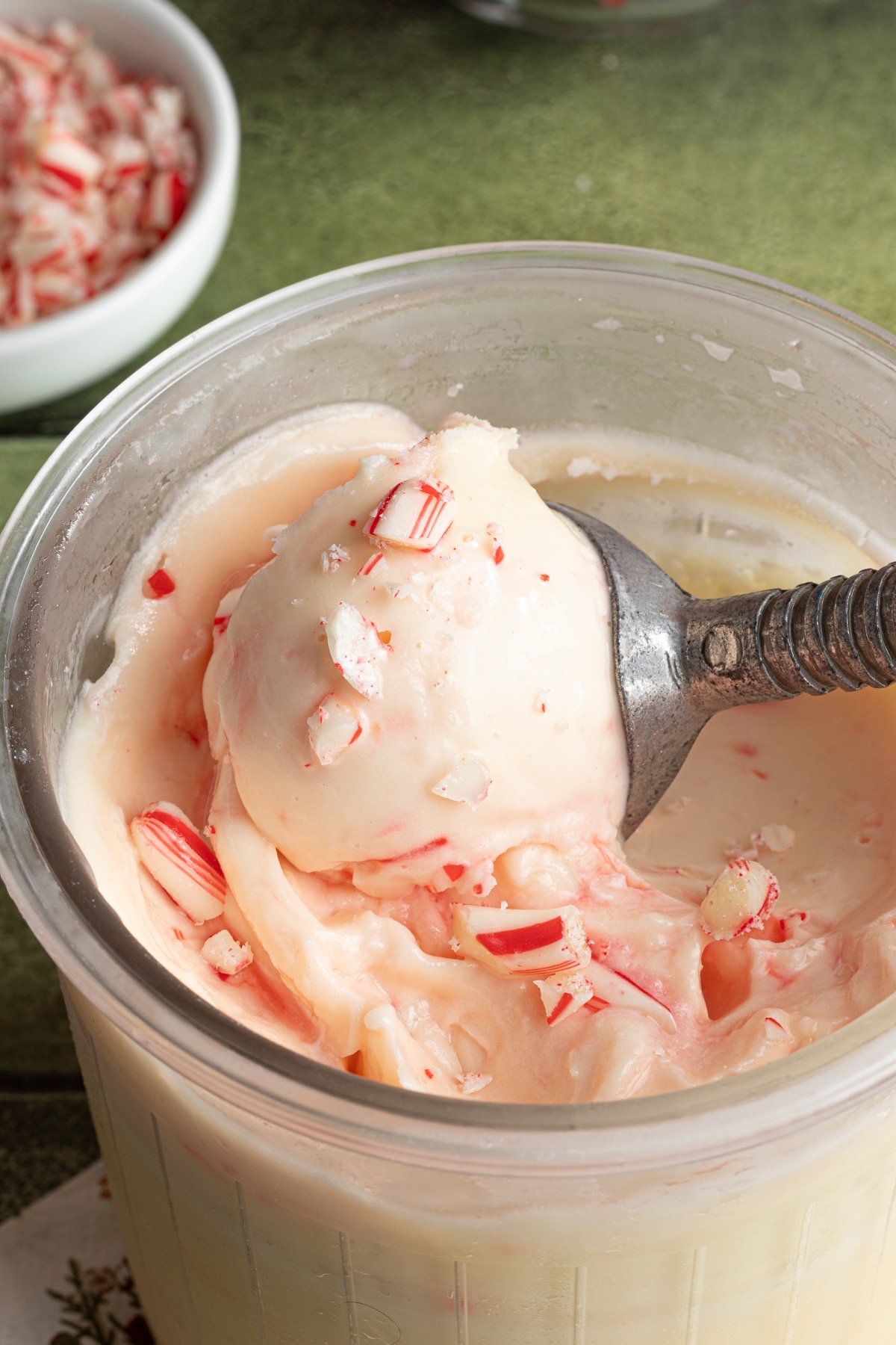 Ninja Creami peppermint ice cream being scooped out of the clear pint container.