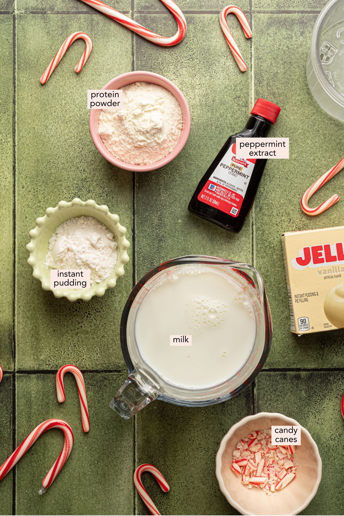 Ninja Creami peppermint ice cream ingredients on a green counter top in individual containers.