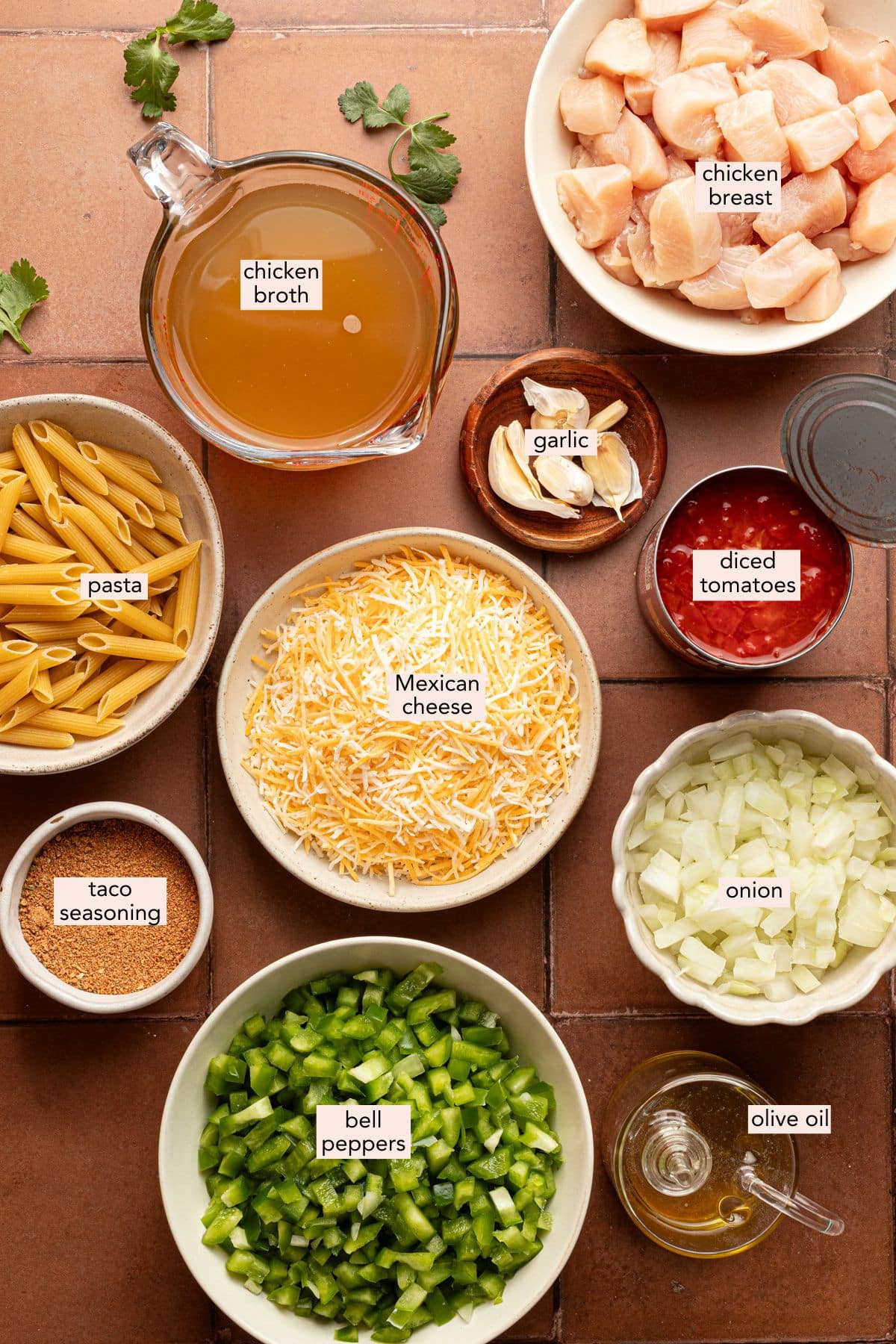 Chicken taco pasta skillet ingredients on a rose countertop in individual bowls.