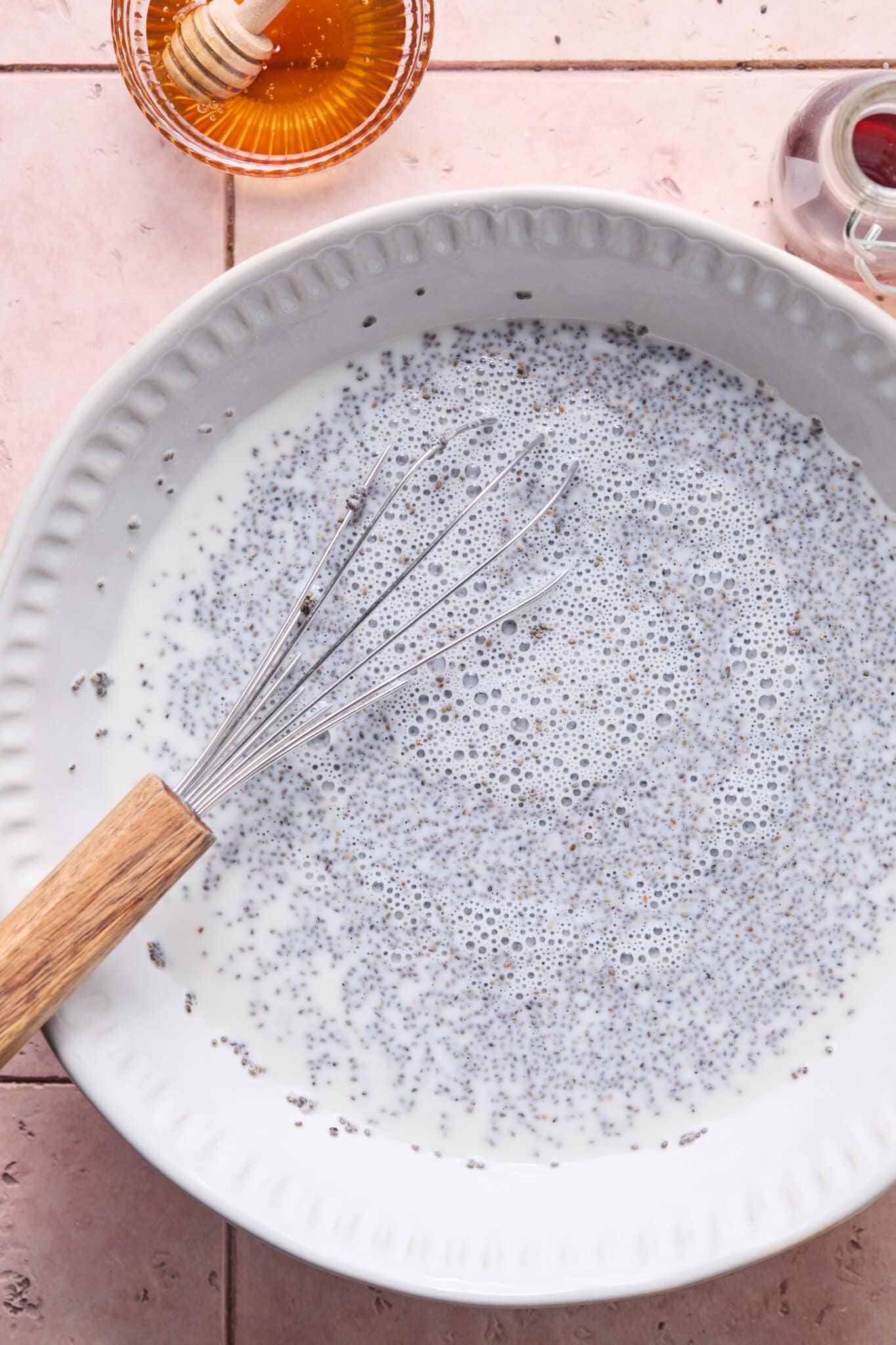 Coconut chia pudding ingredients whisked in a large white bowl.