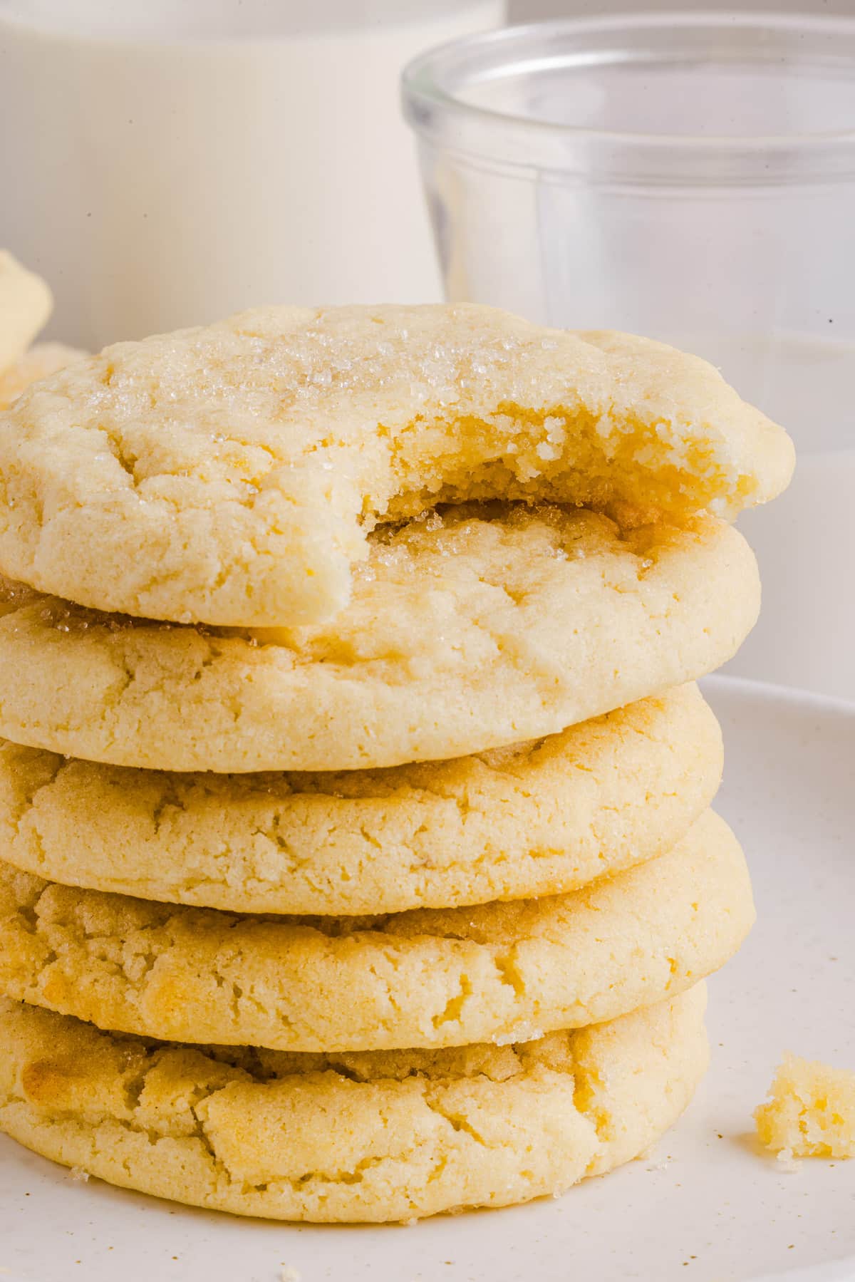 Whole wheat sugar cookies stacked with a bite taken out of the top cookie.
