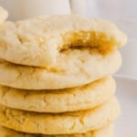 Five whole wheat sugar cookies stacked on top of each other with a bite taken out of the top cookie.