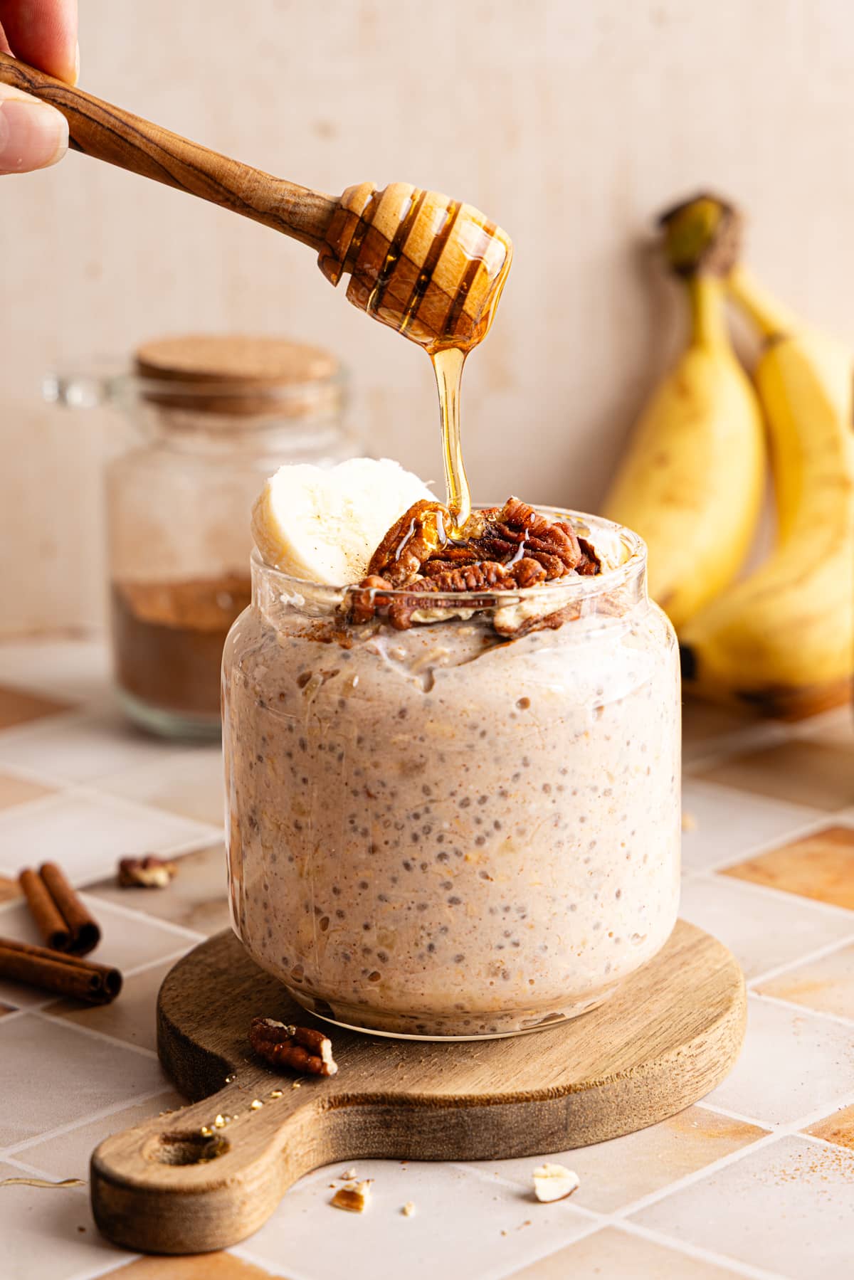 Banana bread overnight oats in a jar being drizzled with honey.