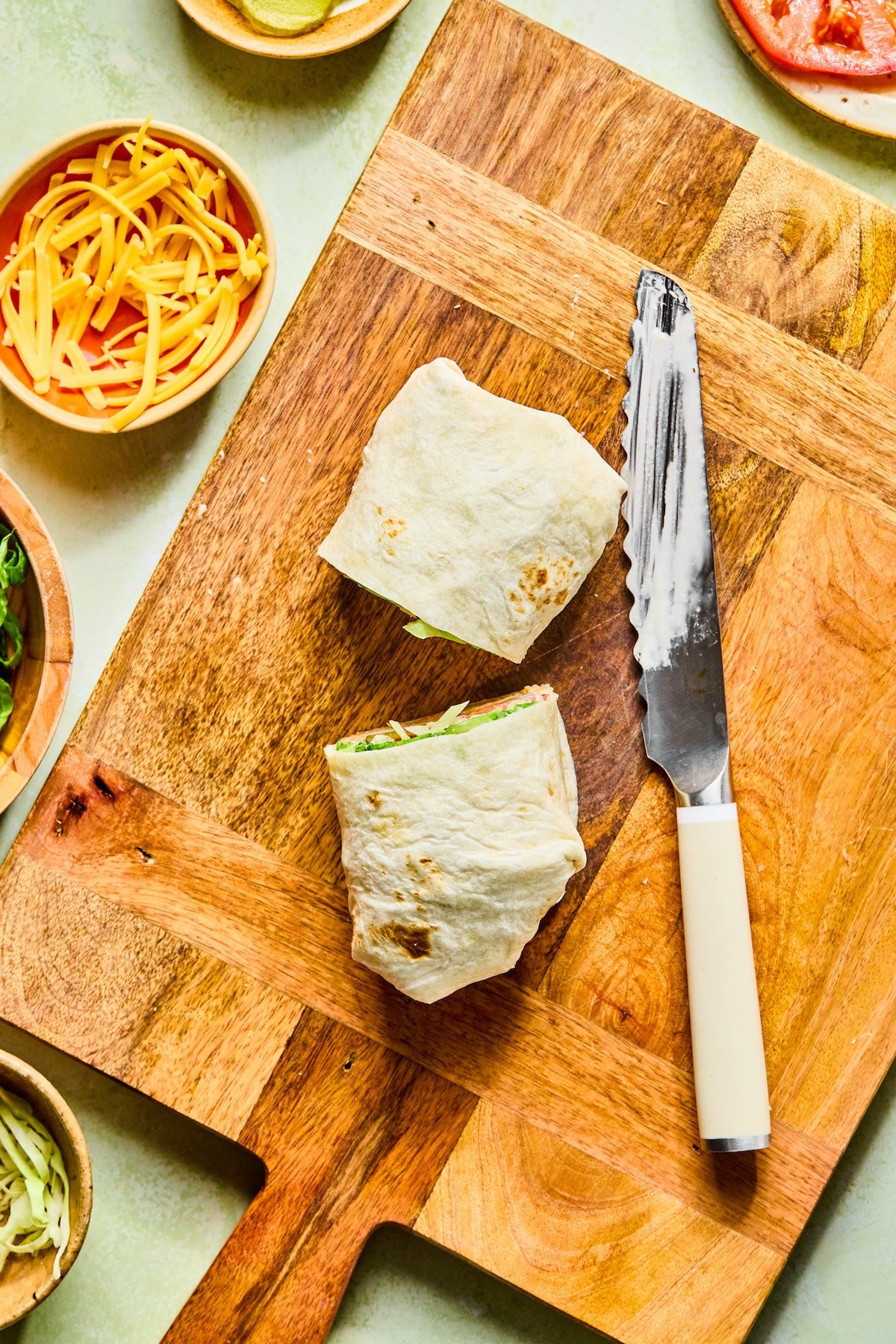 A chicken nugget wrap being sliced in half.