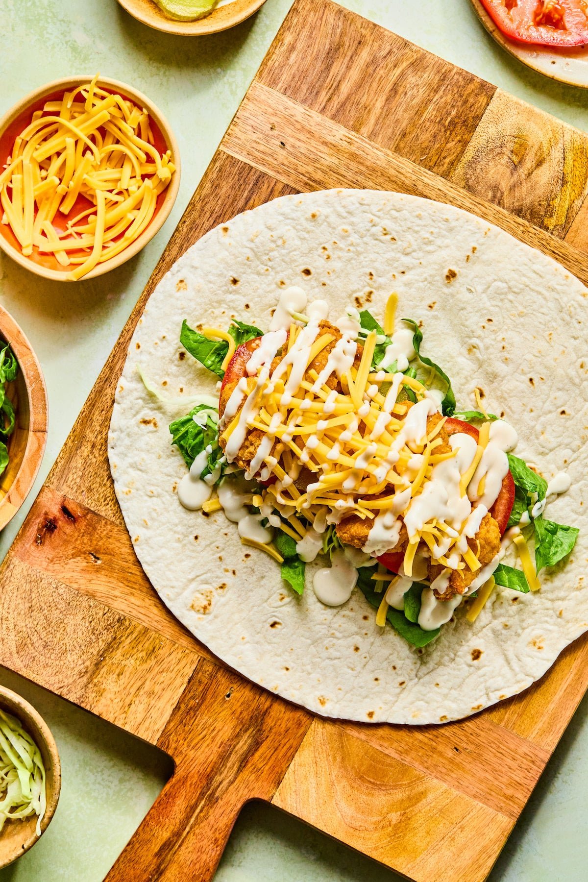 Chicken nugget wrap with veggies and drizzled with ranch dressing.