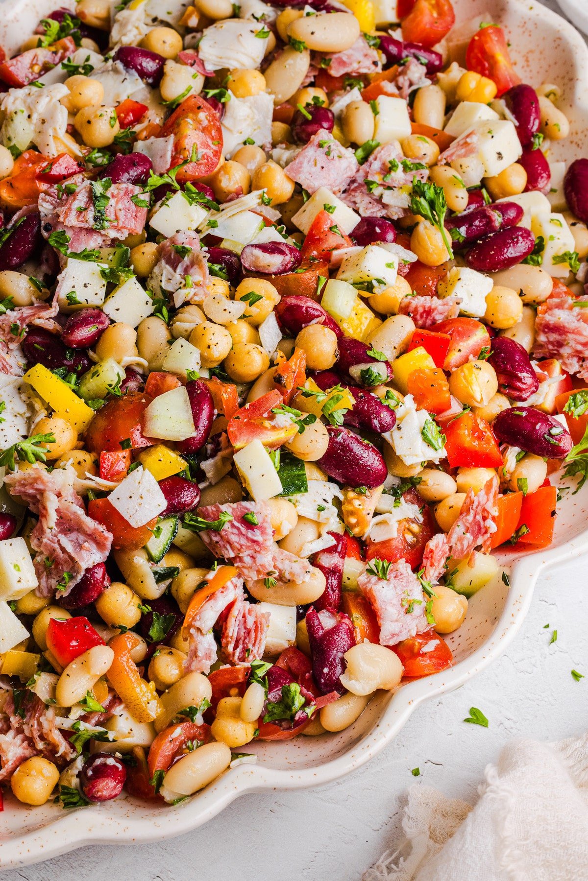 Grinder dense bean salad on a large platter with two serving spoons.