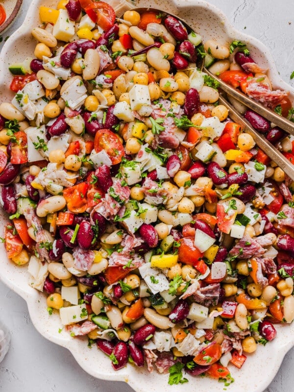 Italian grinder dense bean salad in a platter with serving spoons.