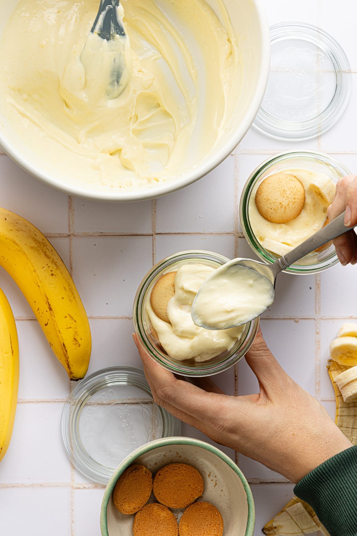 High protein banana pudding being assembled into jars.