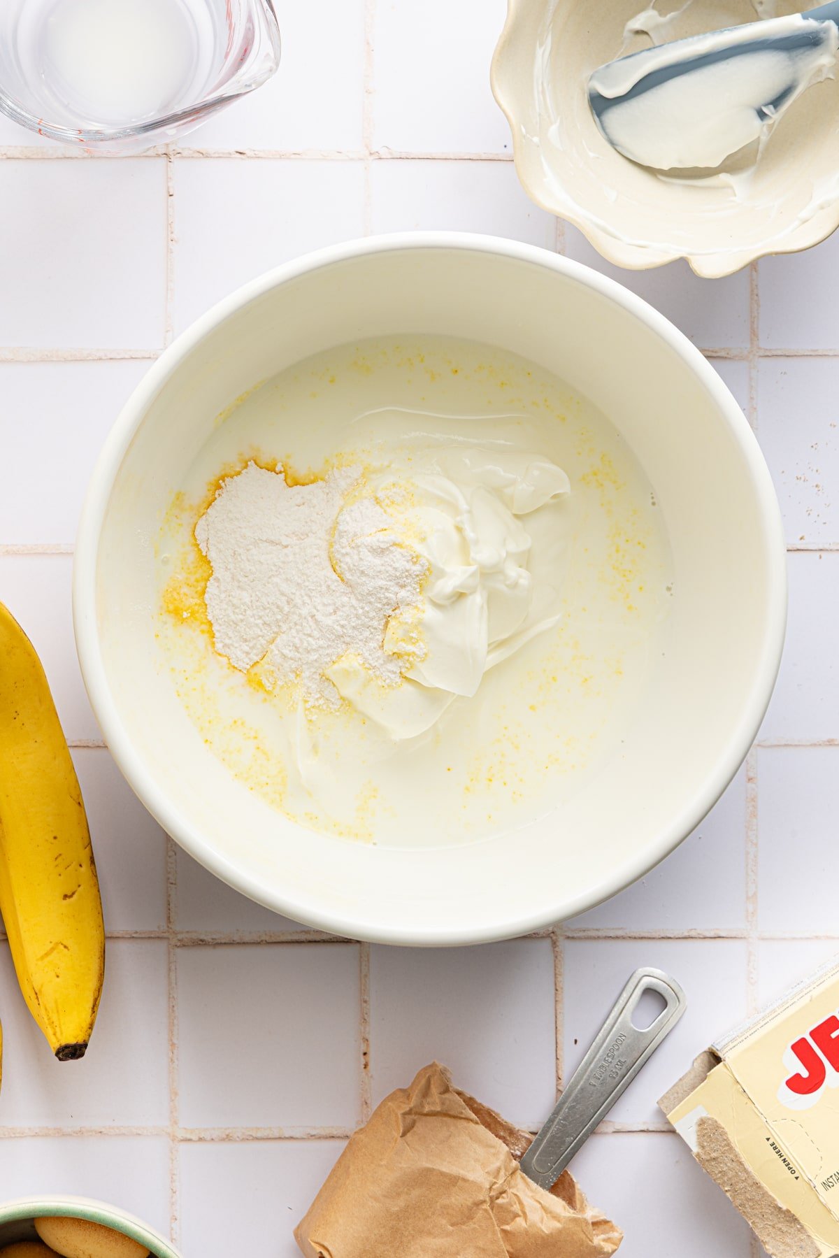 Ingredients for high protein banana pudding in a large bowl about to be mixed.
