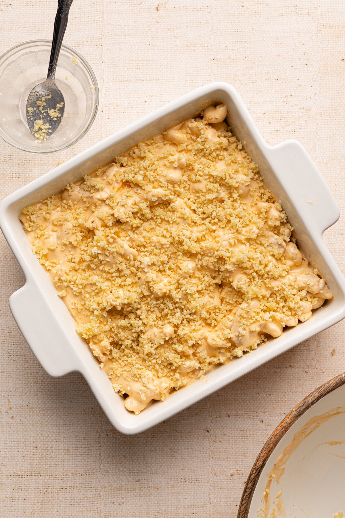 High protein buffalo chicken Mac and cheese mixture in a baking dish topped with breadcrumbs.