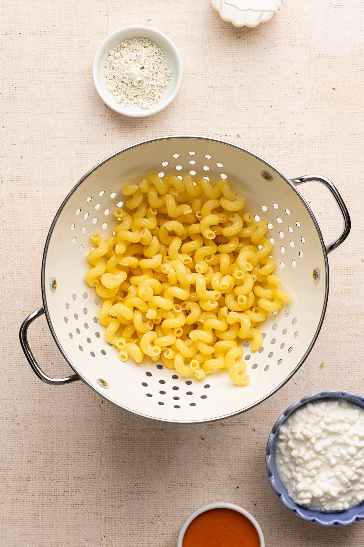 Cooked cavatappi noodles in a white colander.