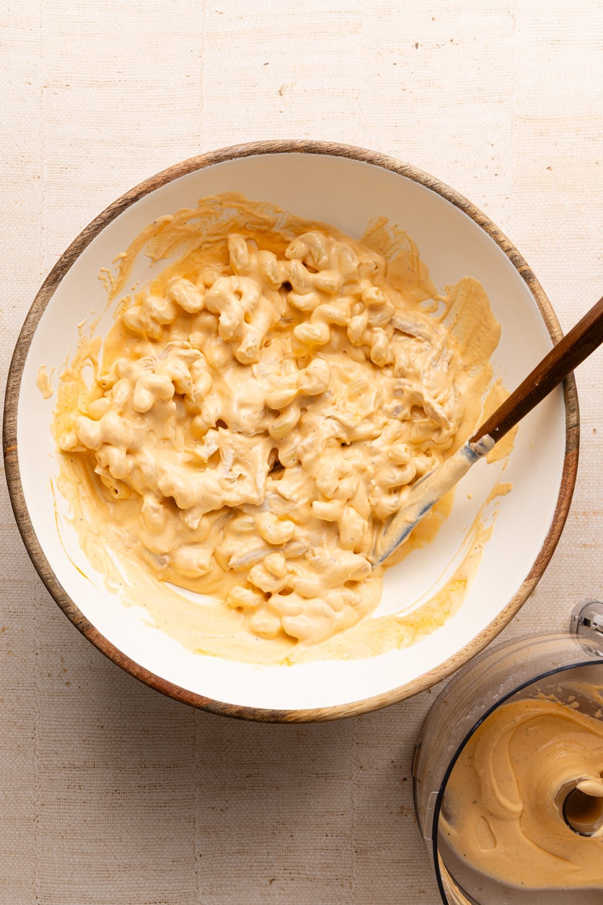Pasta, shredded chicken and cheese sauce mixed in a bowl for high protein buffalo chicken mac and cheese.