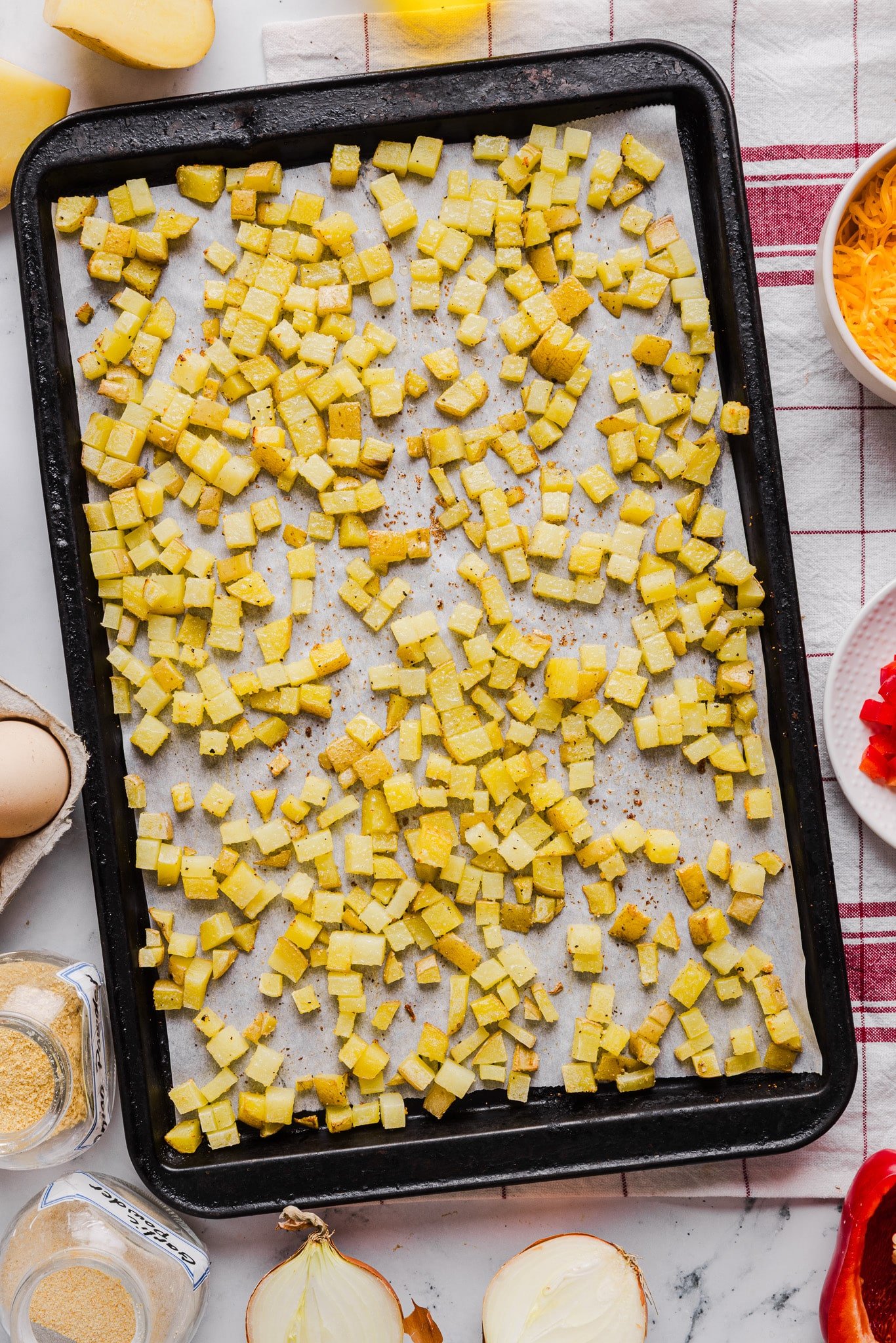 Diced, roasted potatoes on a baking sheet.