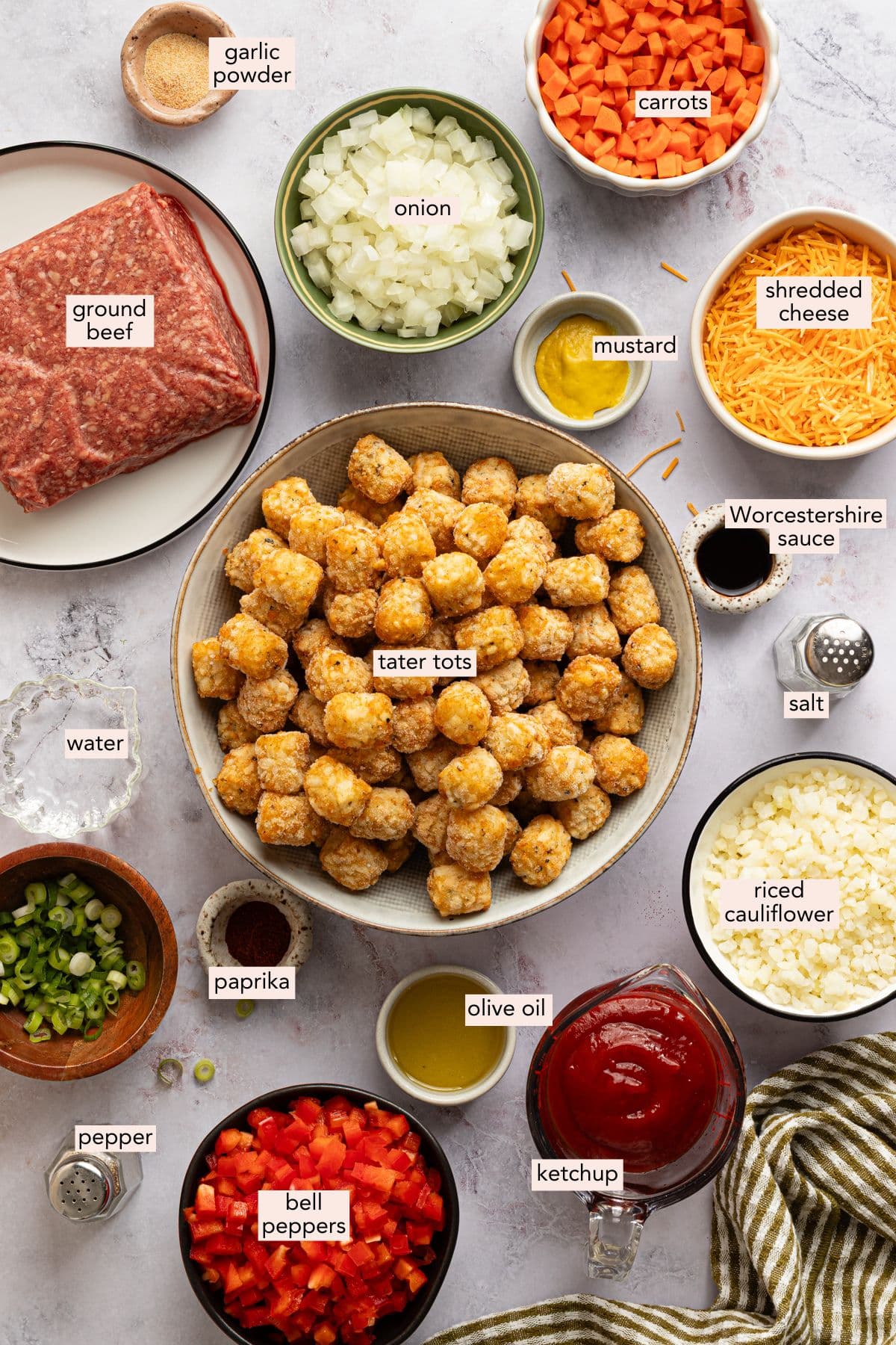 Ingredients for sloppy joe tater tot casserole in individual bowls with labels.