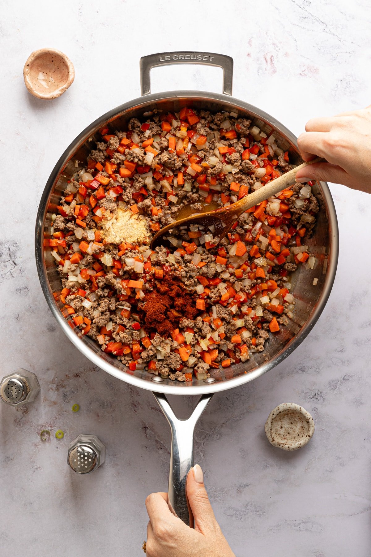 Seasonings for sloppy joe tater tot casserole about to be mixed into a skillet with meat and vegetables.