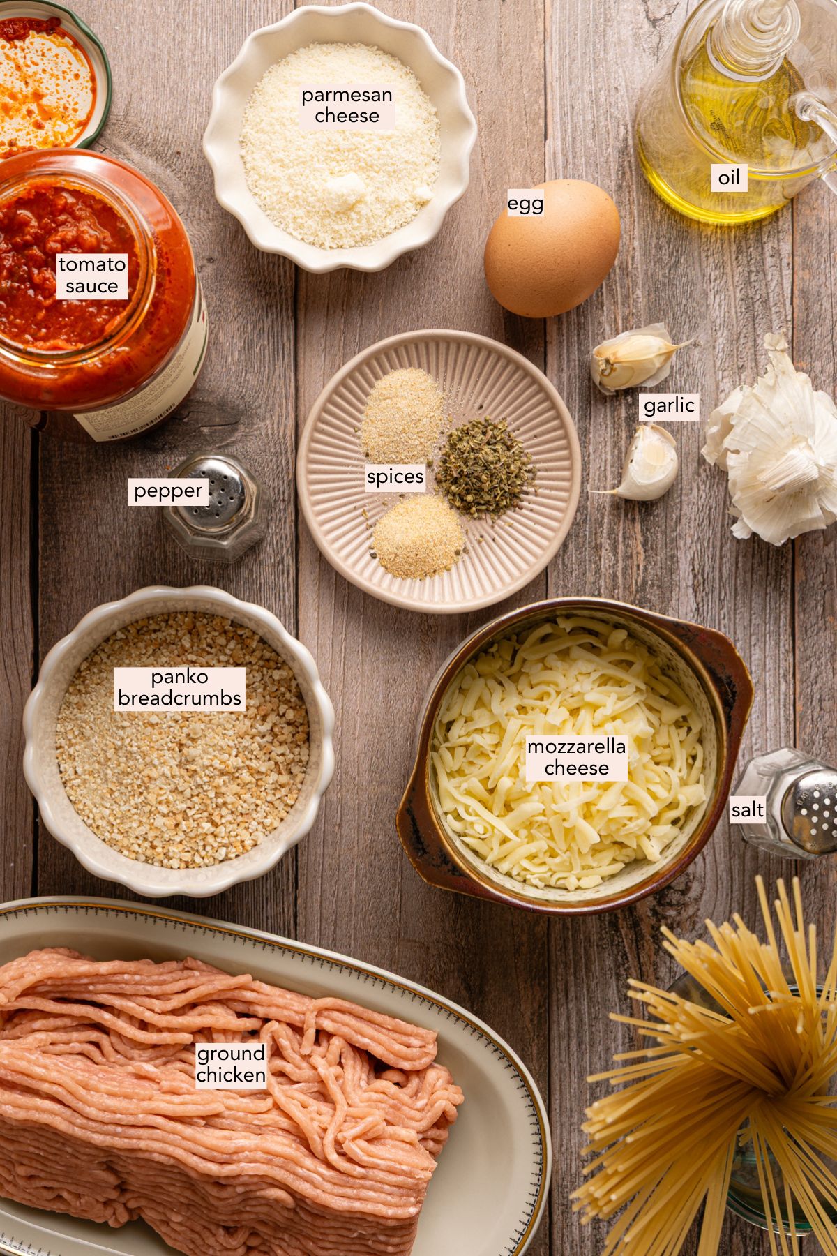 Ingredients for chicken parmesan meatballs on a countertop with labels.