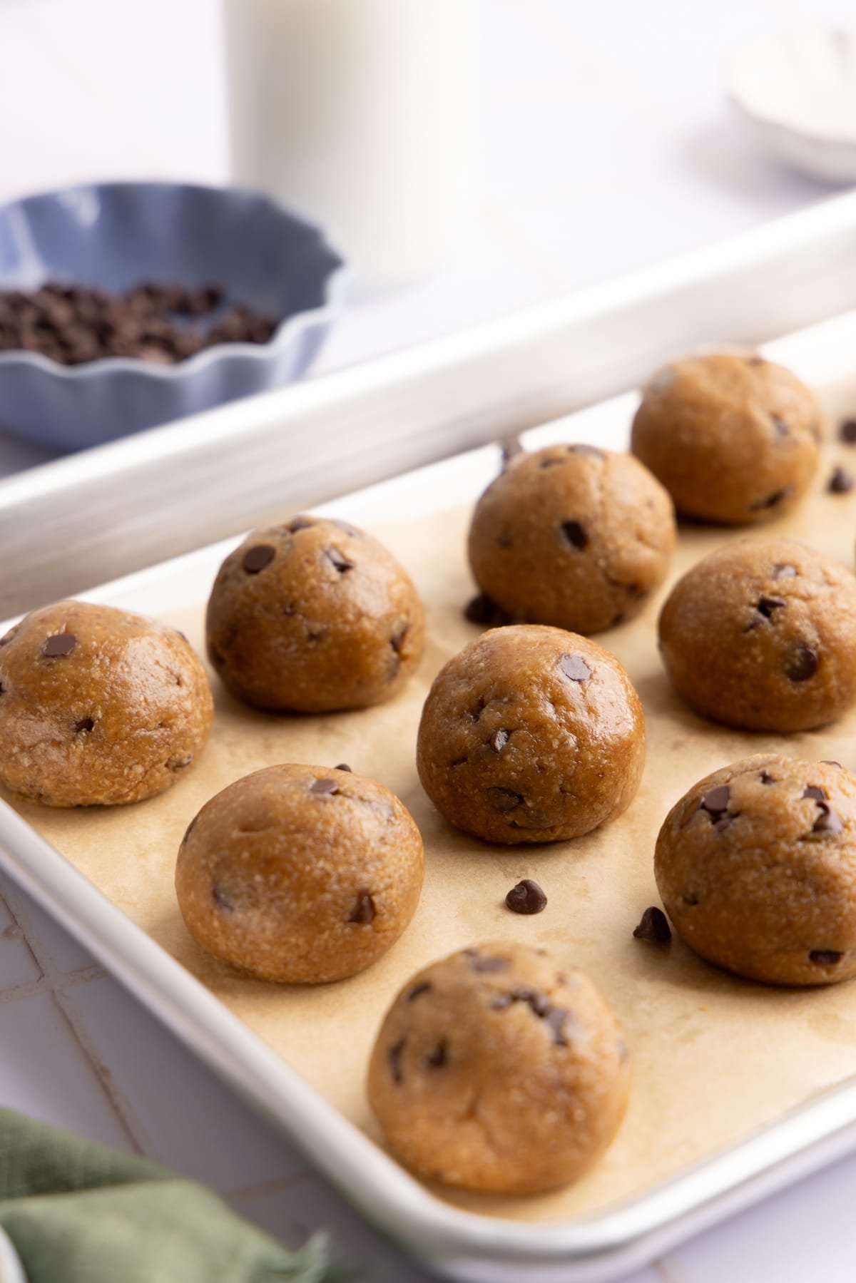 Cookie dough protein balls on a sheet pan with parchment paper.