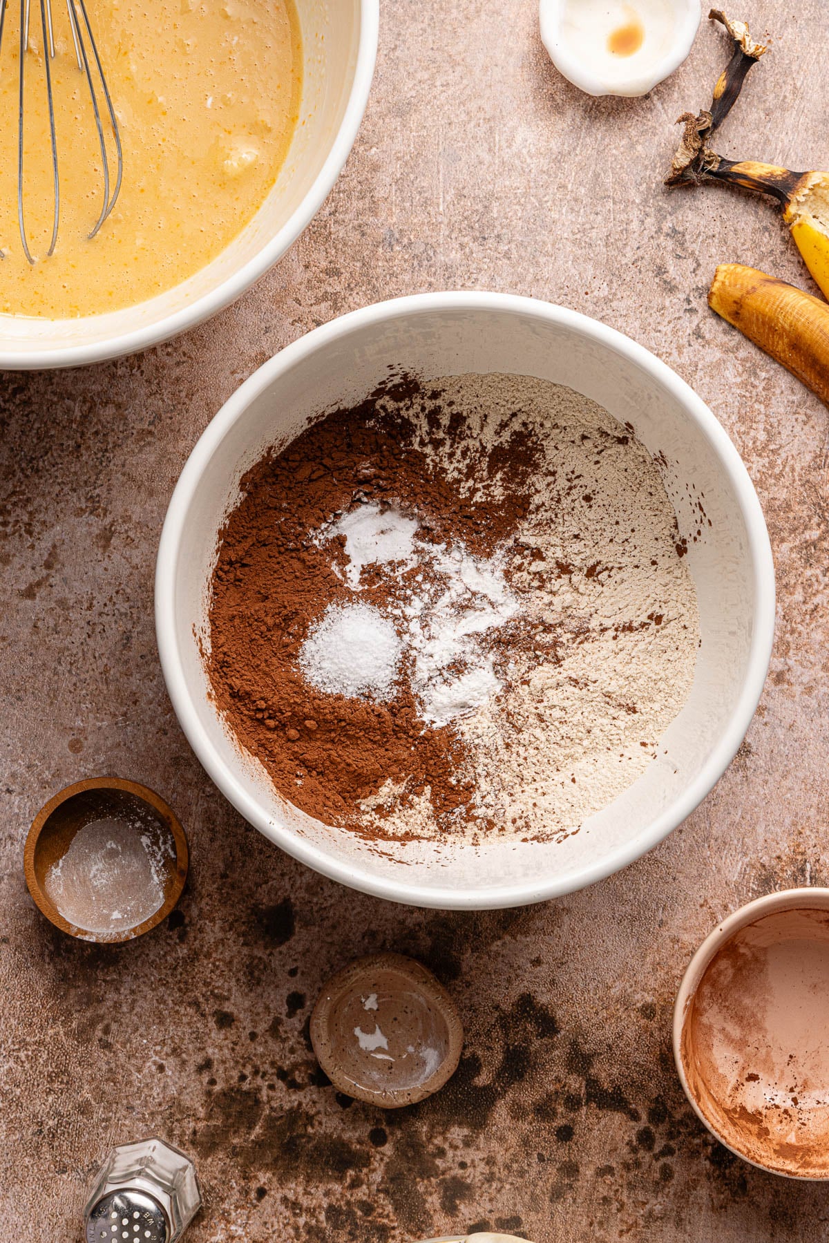 All of the dry ingredients (except for the chocolate chips) in a white bowl on a countertop.